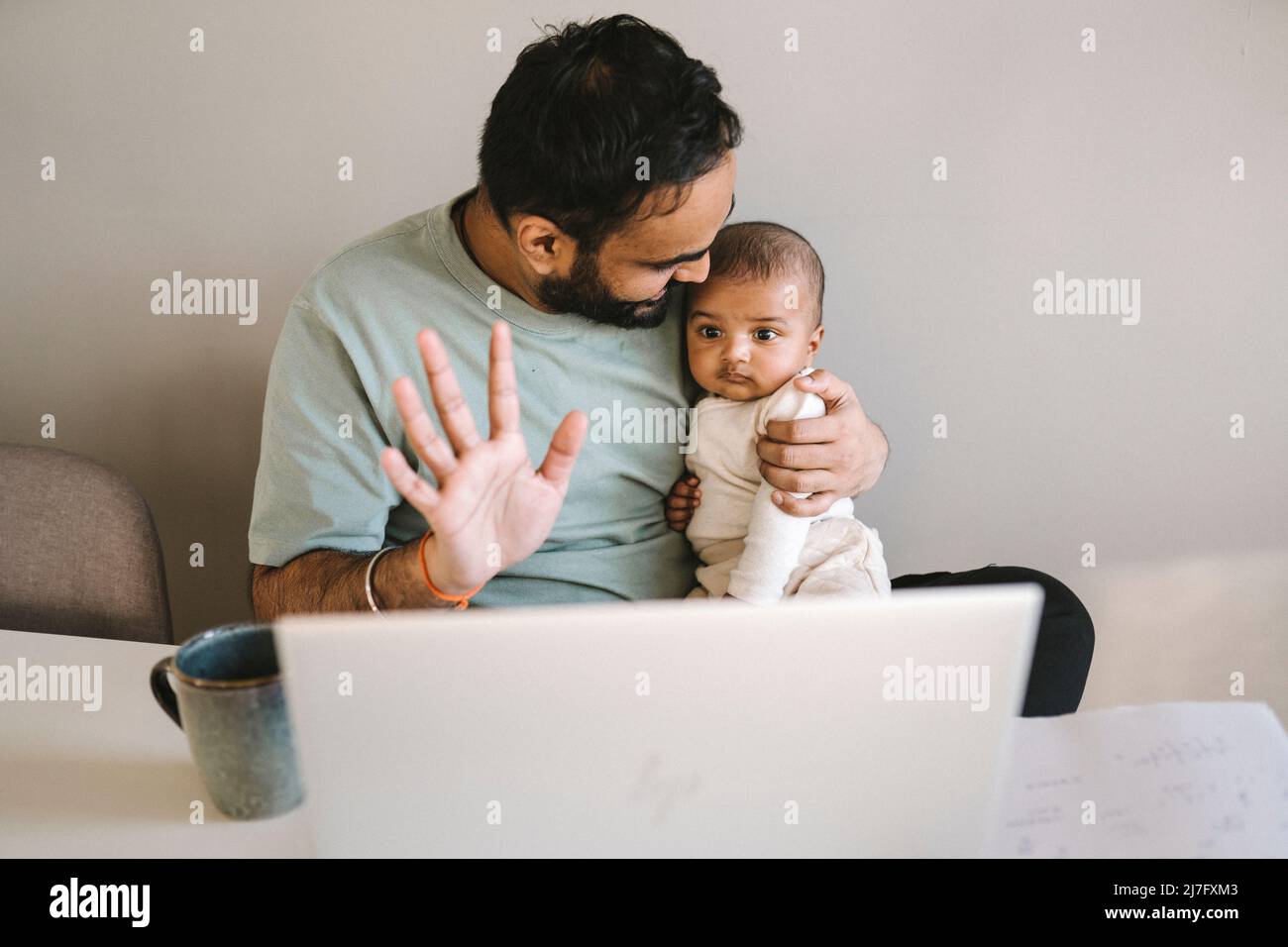 Father with baby working from home Stock Photo