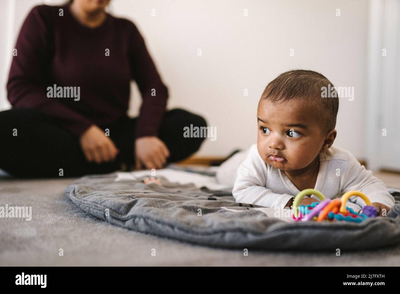 Mother with baby playing on floor Stock Photo - Alamy