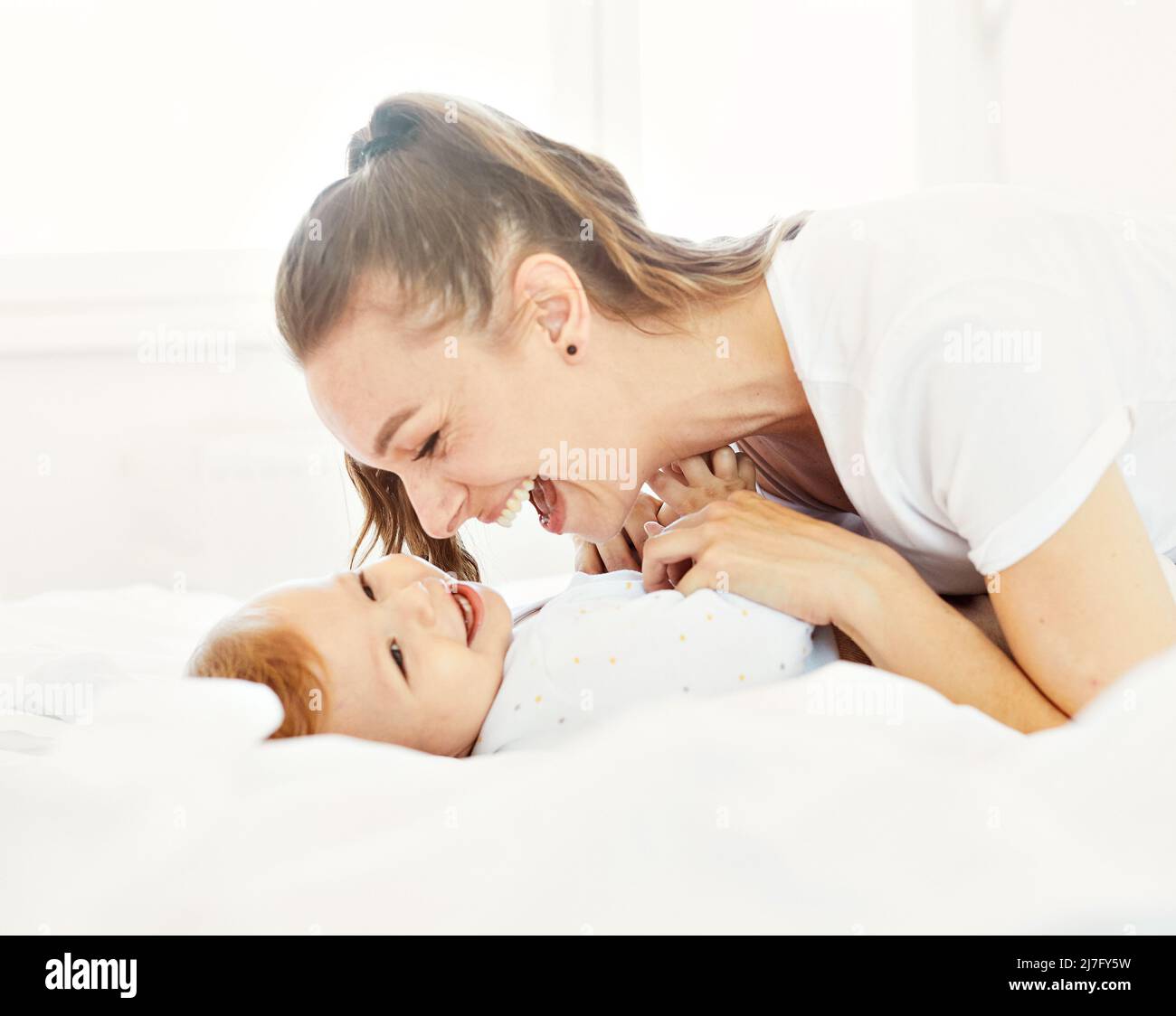 mother child baby having fun family happy childhood care cheerful cute boy sun Stock Photo