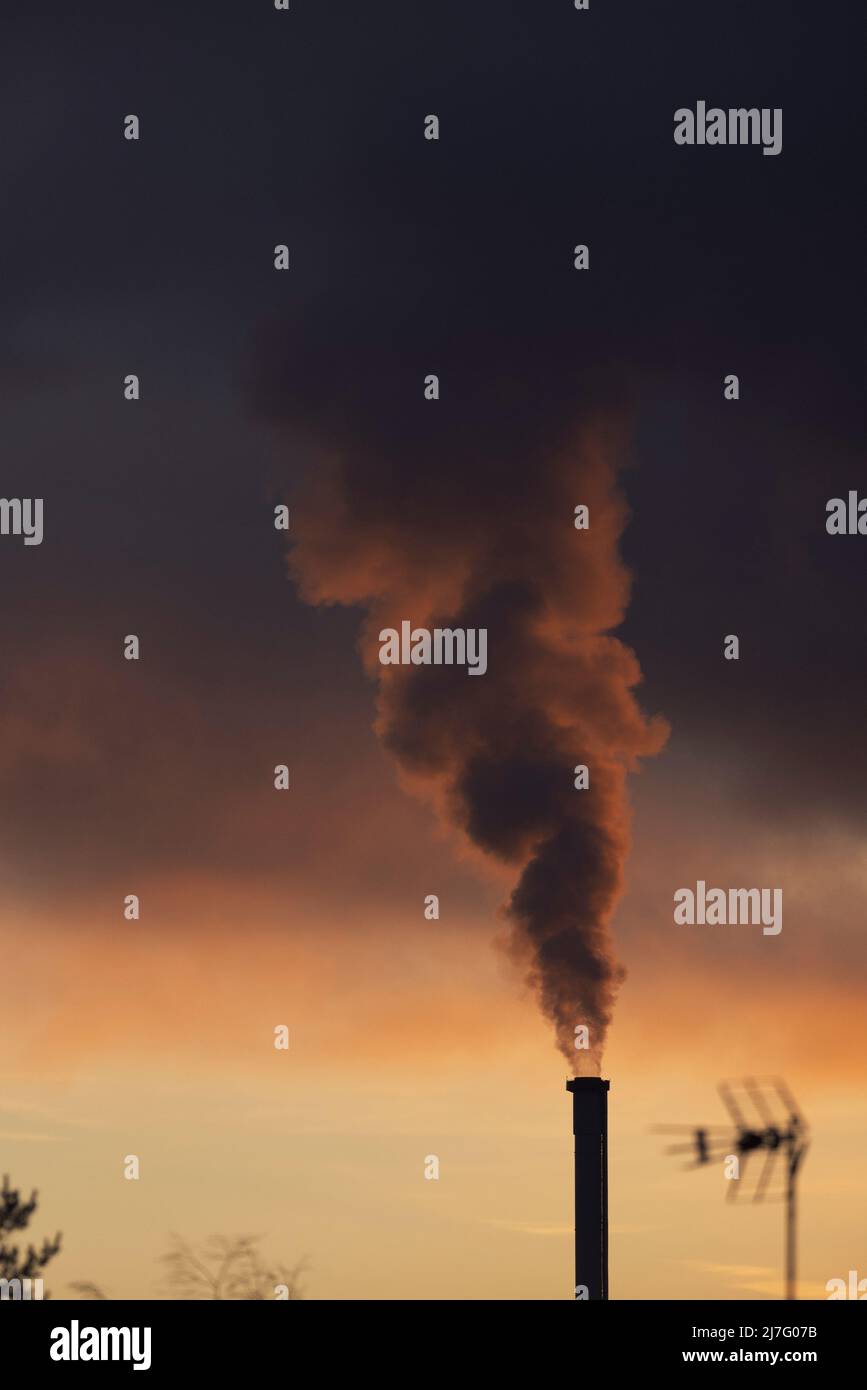 Smoke stack emitting smoke into evening sky Stock Photo - Alamy
