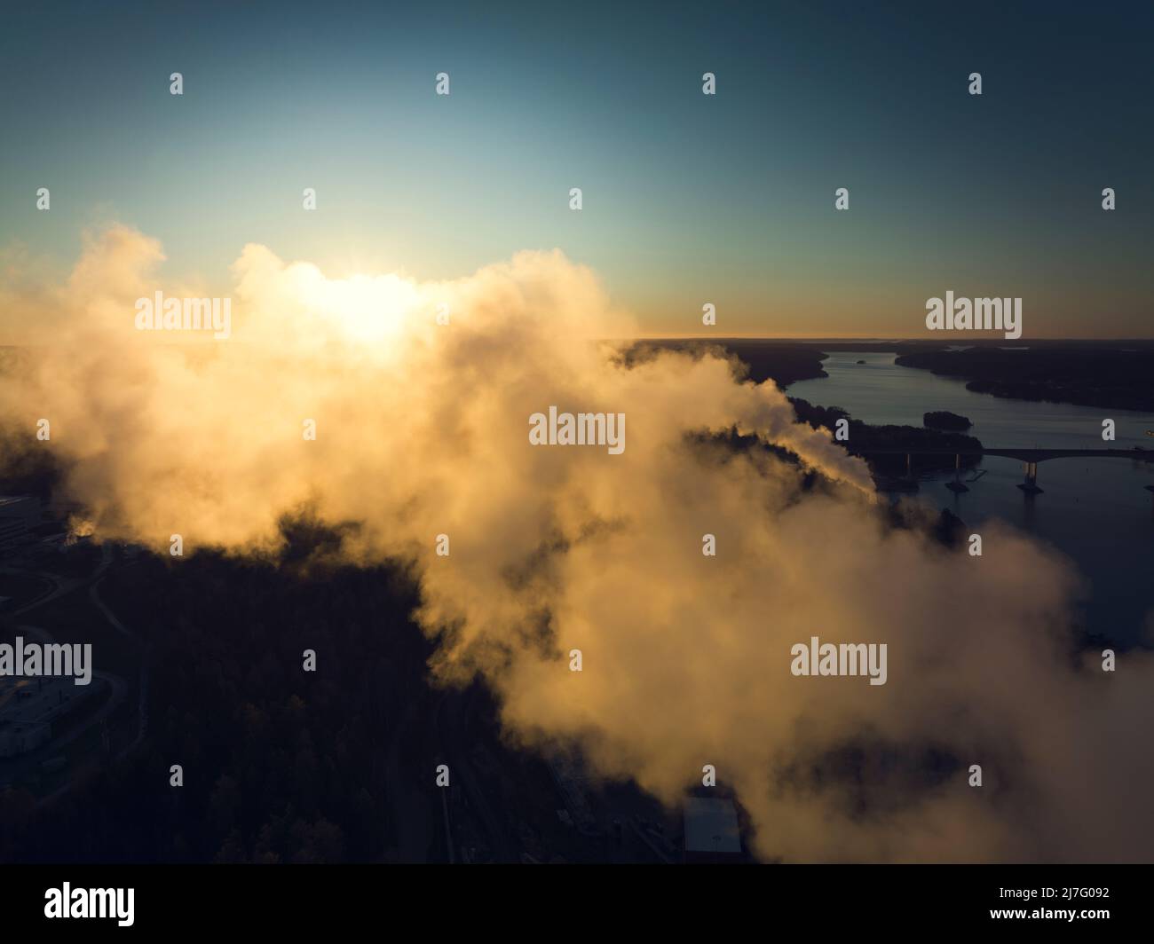 Smoke stacks emitting smoke at sunset Stock Photo