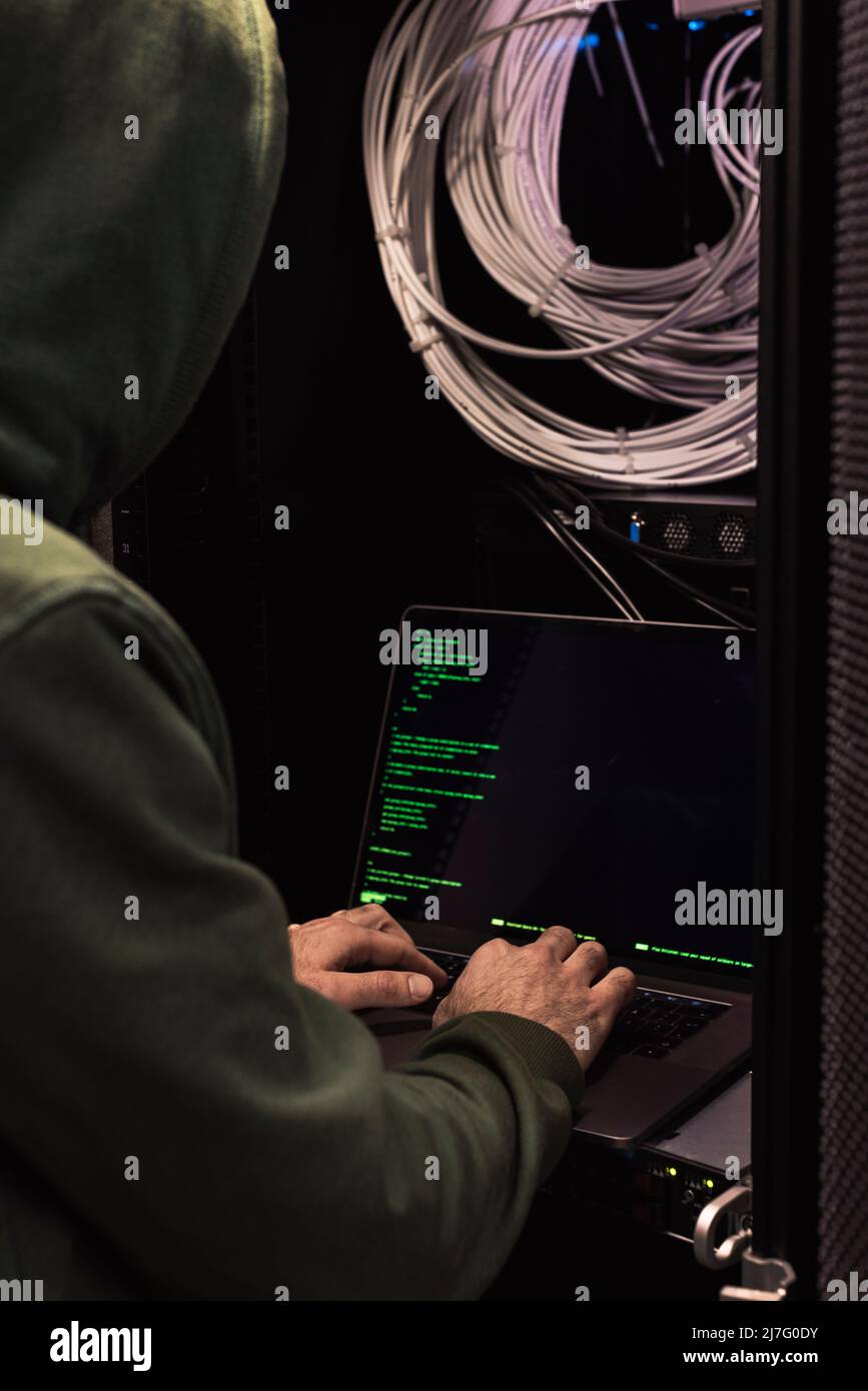 IT technician working on laptop in server room Stock Photo