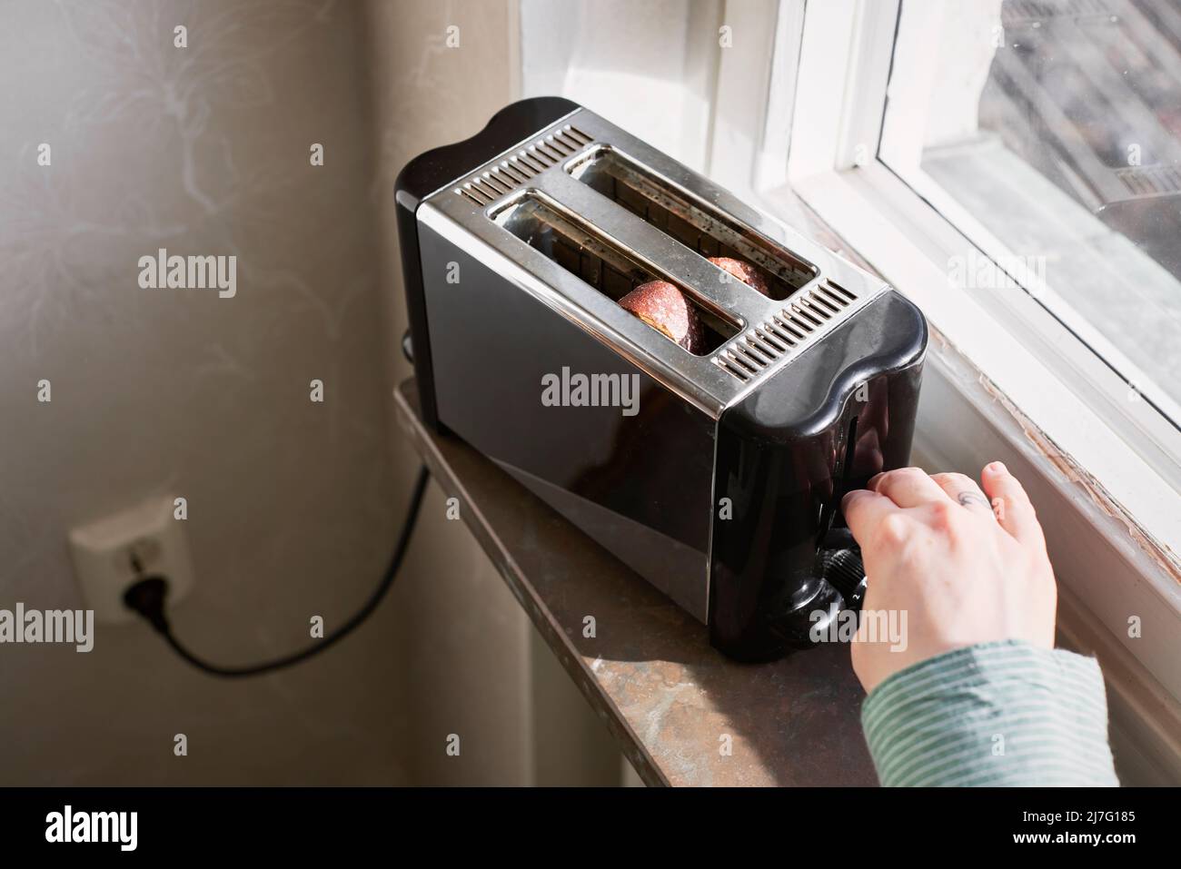Hands putting toasts inside toaster Stock Photo Alamy