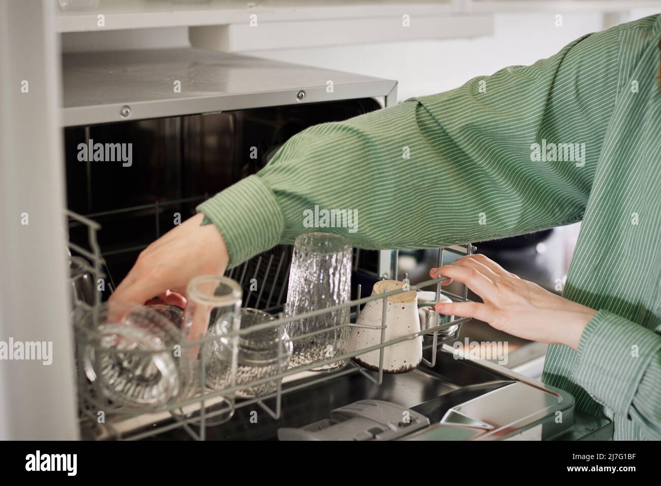 Woman putting dishes into dishwasher Stock Photo Alamy