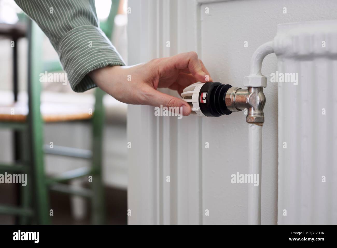 Hand adjusting temperature control in radiator Stock Photo - Alamy