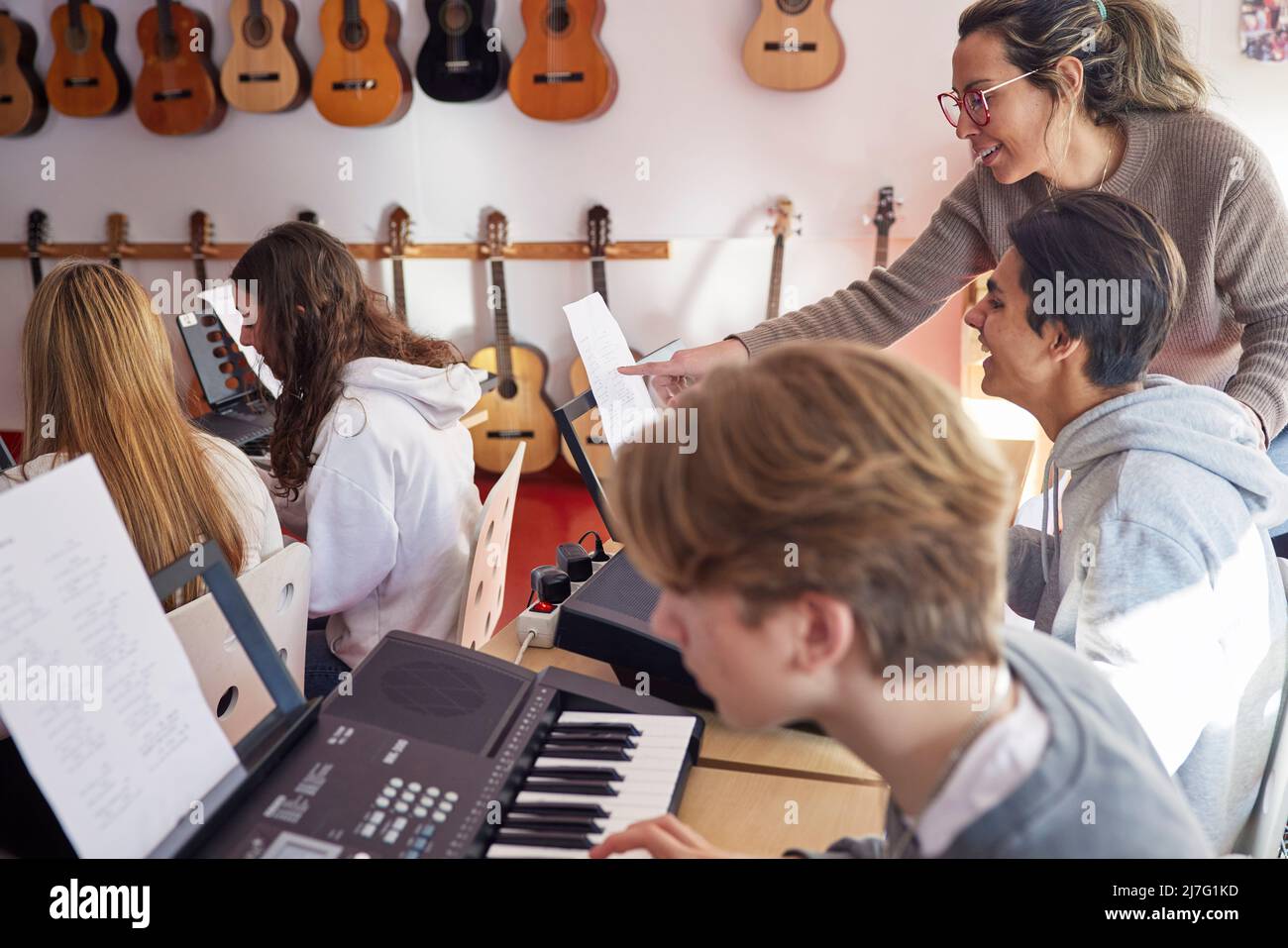 Teenagers and teacher during keyboard lesson Stock Photo Alamy
