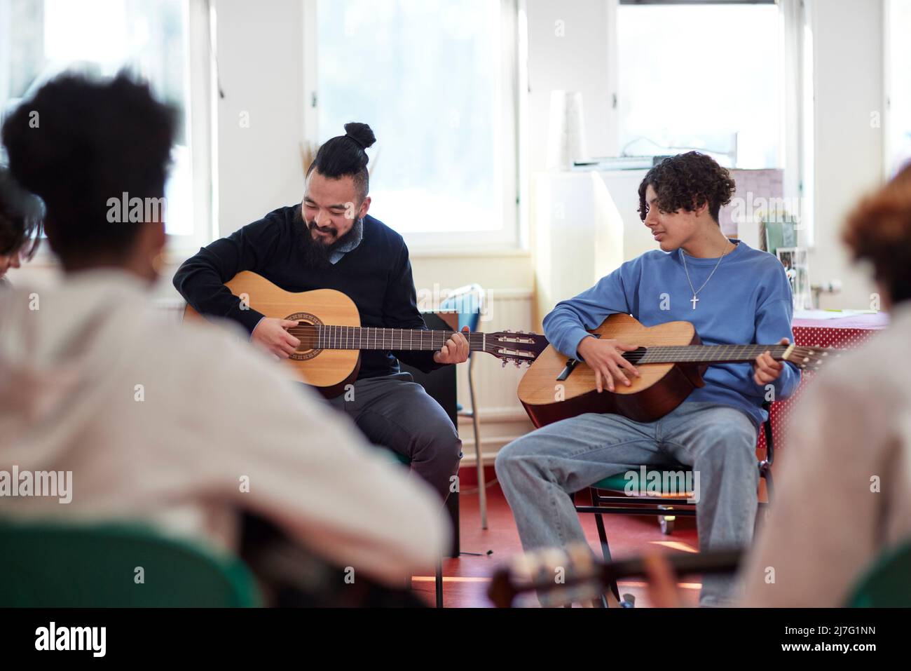 Teenagers attending guitar lesson Stock Photo