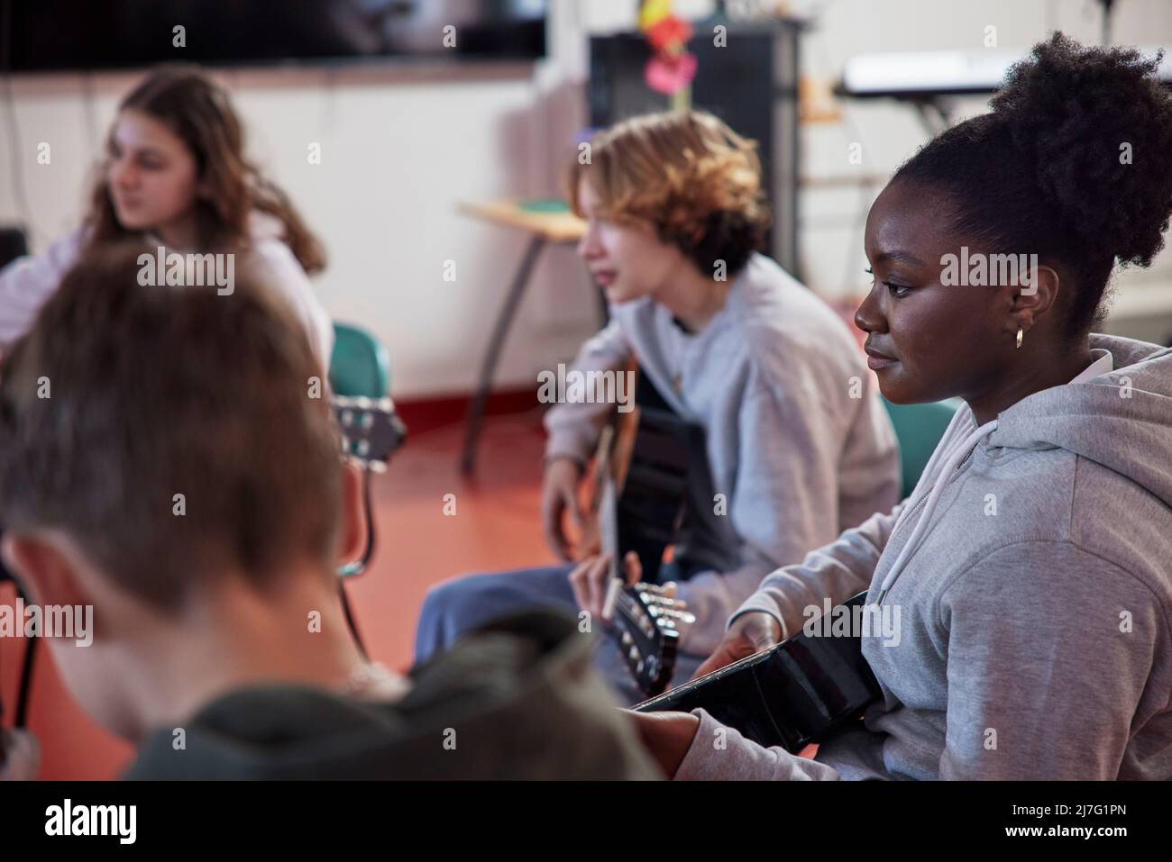 Teenagers attending guitar lesson Stock Photo