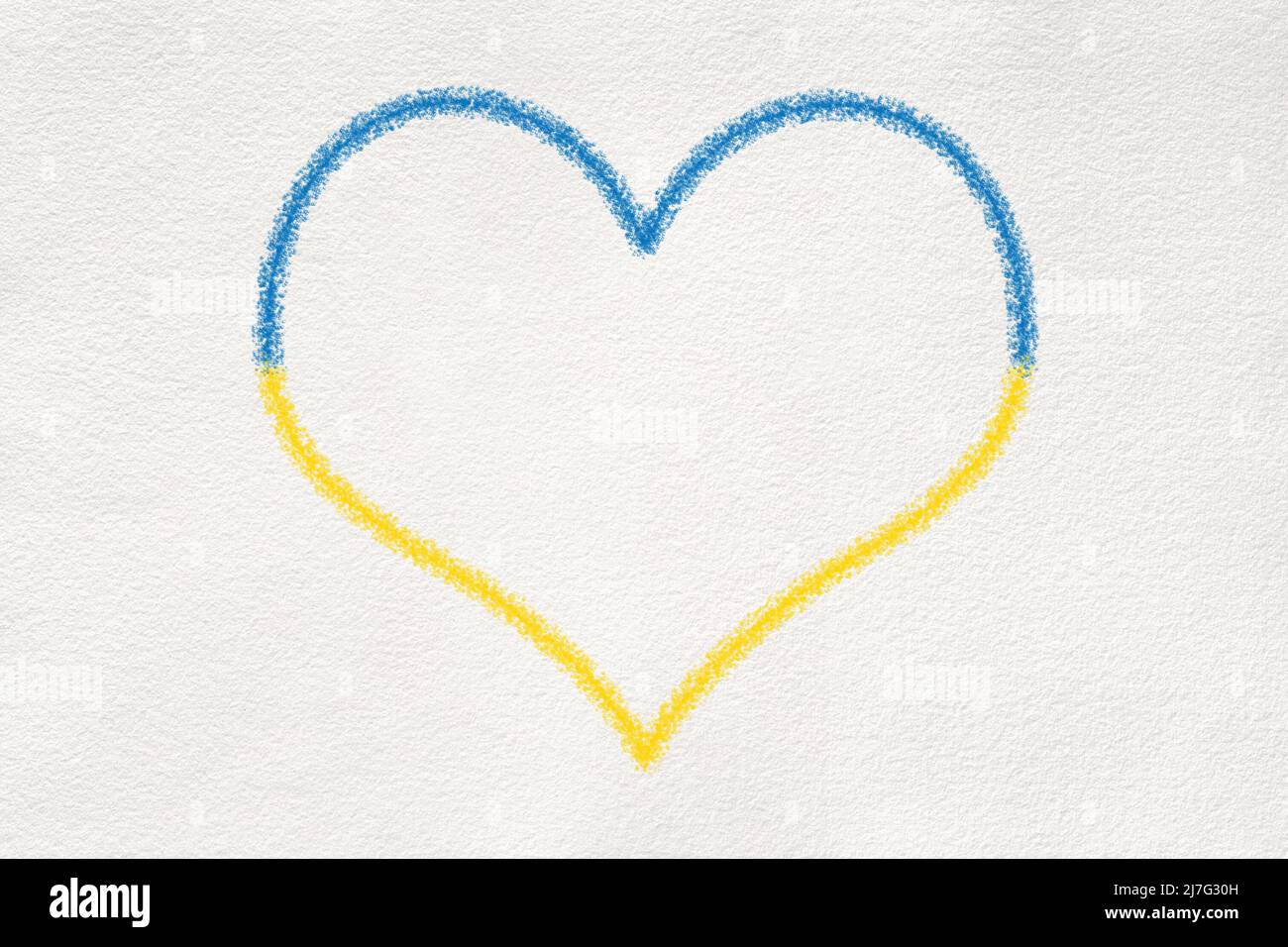 Heart shape crayon drawing on white textured paper in Ukrainian Flag colors: blue and yellow. Stock Photo
