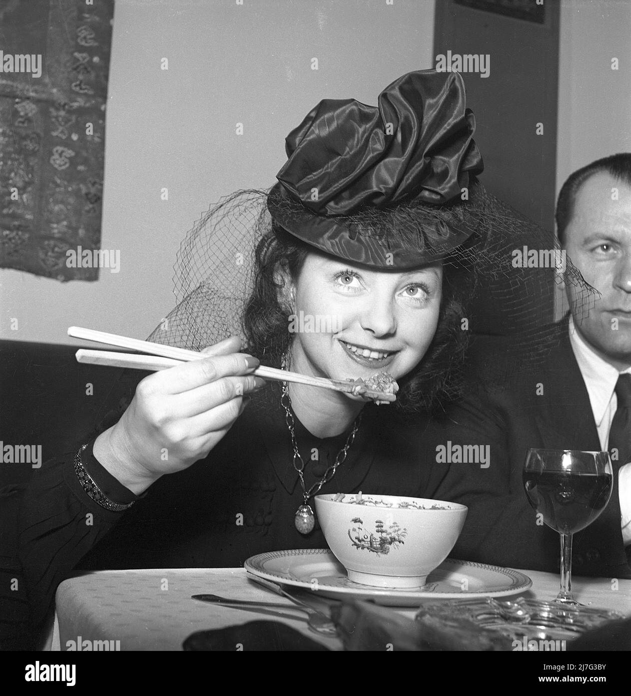Chinese food being served for the first time ever in a swedish restaurant 1944. It is actress Marguerite Viby who looks as if she can handle the chopsticks and enjoys the novelty food. The restaurant Berns in Stockholm has four chinese chefs cooking traditional chinese cuisine for the first time in a swedish restaraunt. Sweden Kristoffersson G53-5 Stock Photo