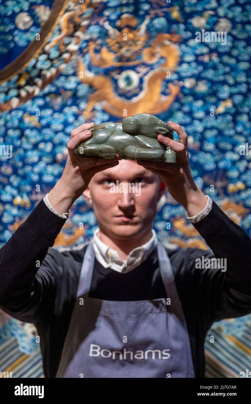 London, UK.  9 May 2022. A technician presents “A Very Rare Large Jade Carving Of A Water Buffalo”, Qianlong, (Est. £120,000 - £180,000) at a preview of Bonhams’ Fine Chinese Art sale at their New Bond Street gallery.  Chinese jades, ceramics, lacquerware, Imperial and Court textiles and works of art will be offered for sale 12 May.  Credit: Stephen Chung / Alamy Live News Stock Photo