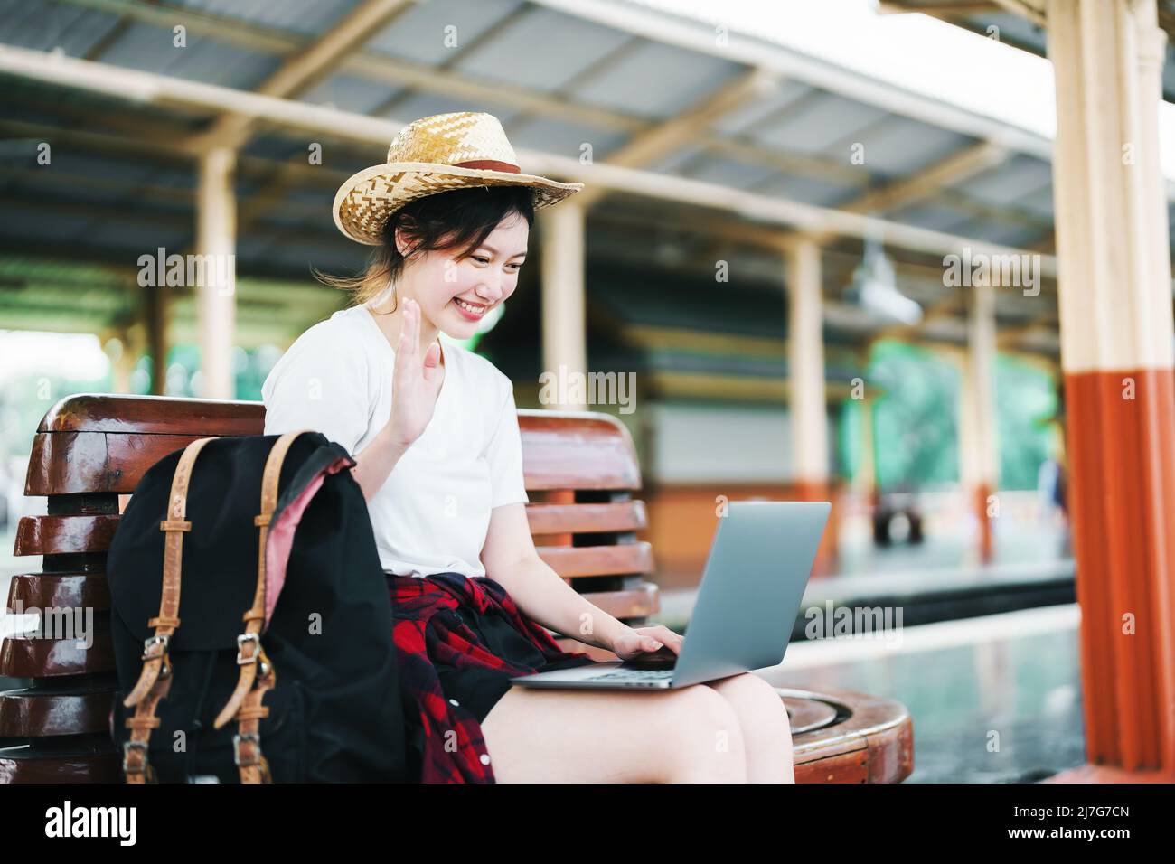 summer, relax, vacation, travel, portrait of beautiful Asian girl using the computer laptop at the train station while waiting for their travel time. Stock Photo