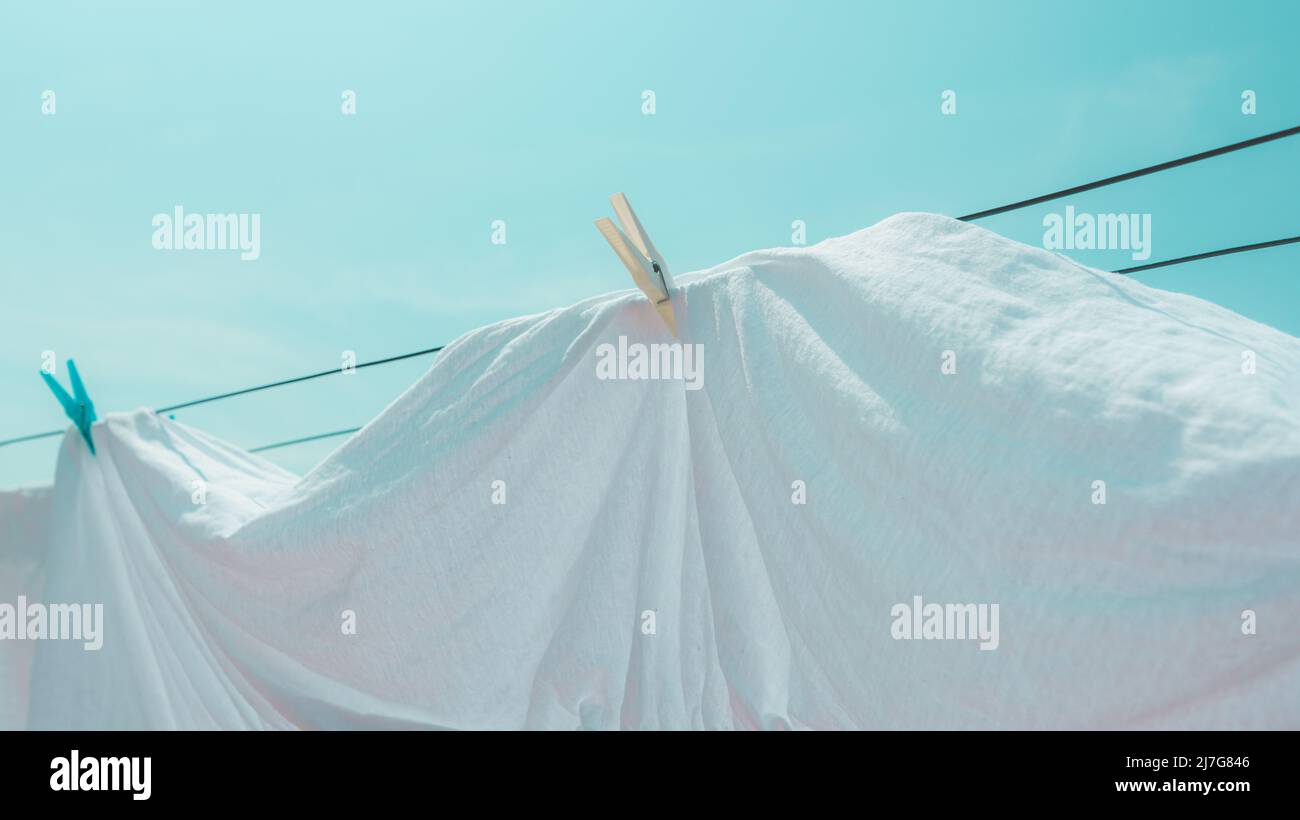 Drying bed sheets outdoor in hot summer air, selective focus Stock Photo