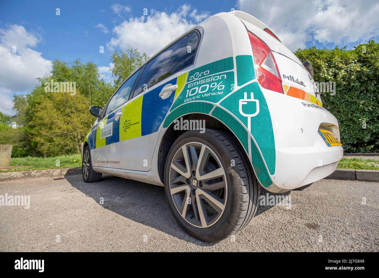 Close up of new electric Zero Emission Seat Mii police car (nearside rear) of West Mercia Force isolated outdoors in public park in UK spring sunshine. Stock Photo