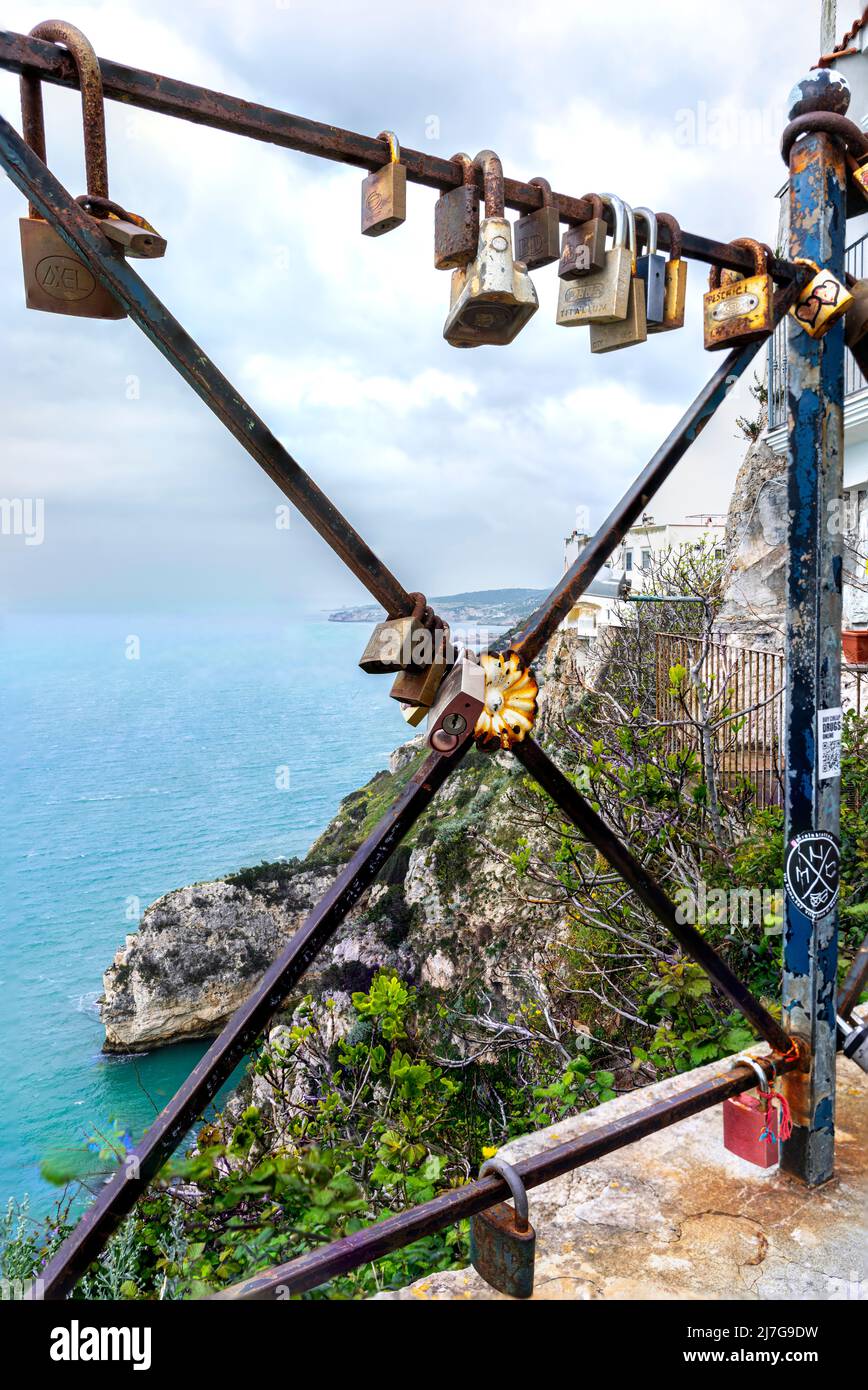 padlocks placed on the balcony of the medieval castle of Peschici. In the background the gulf and the promontory of the city. Peschici, Foggia. Stock Photo