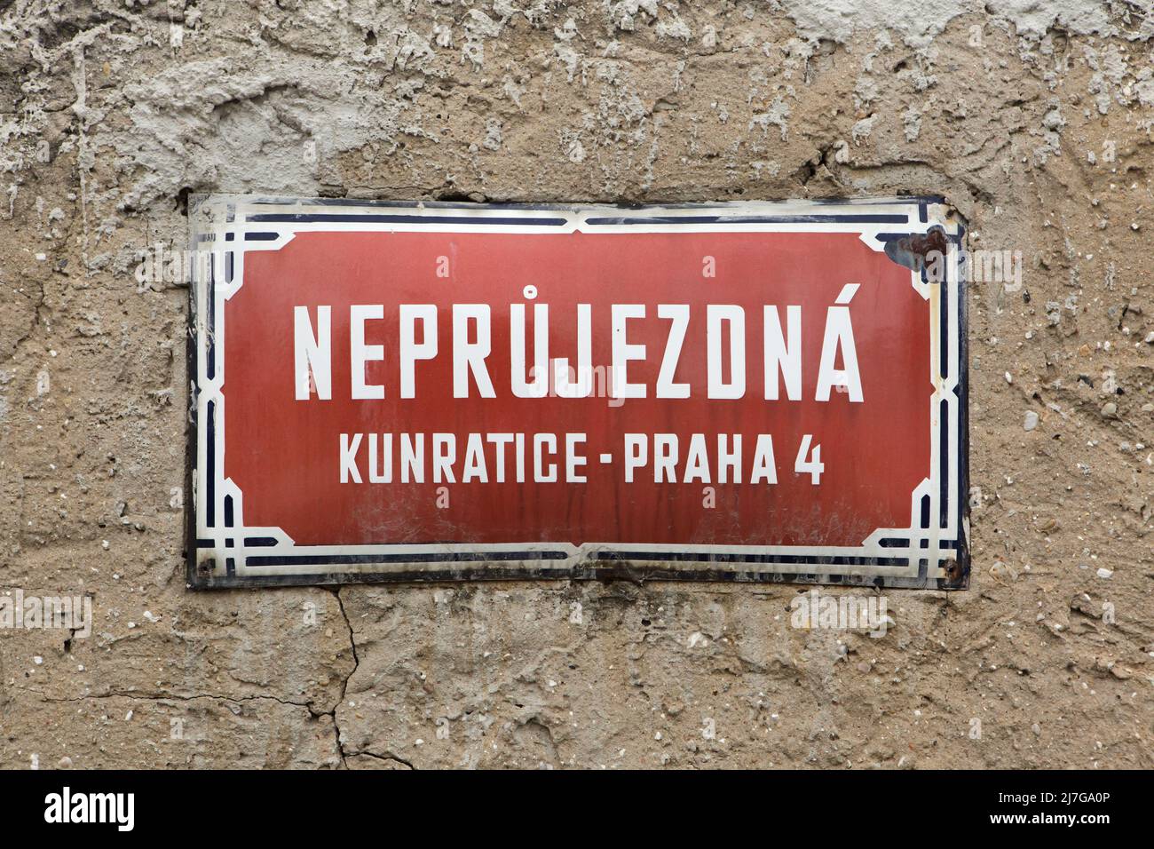 Neprůjezdná Street. Traditional red street sign in Kunratice district in Prague, Czech Republic. The street name is literary translated as the impassable street. Stock Photo