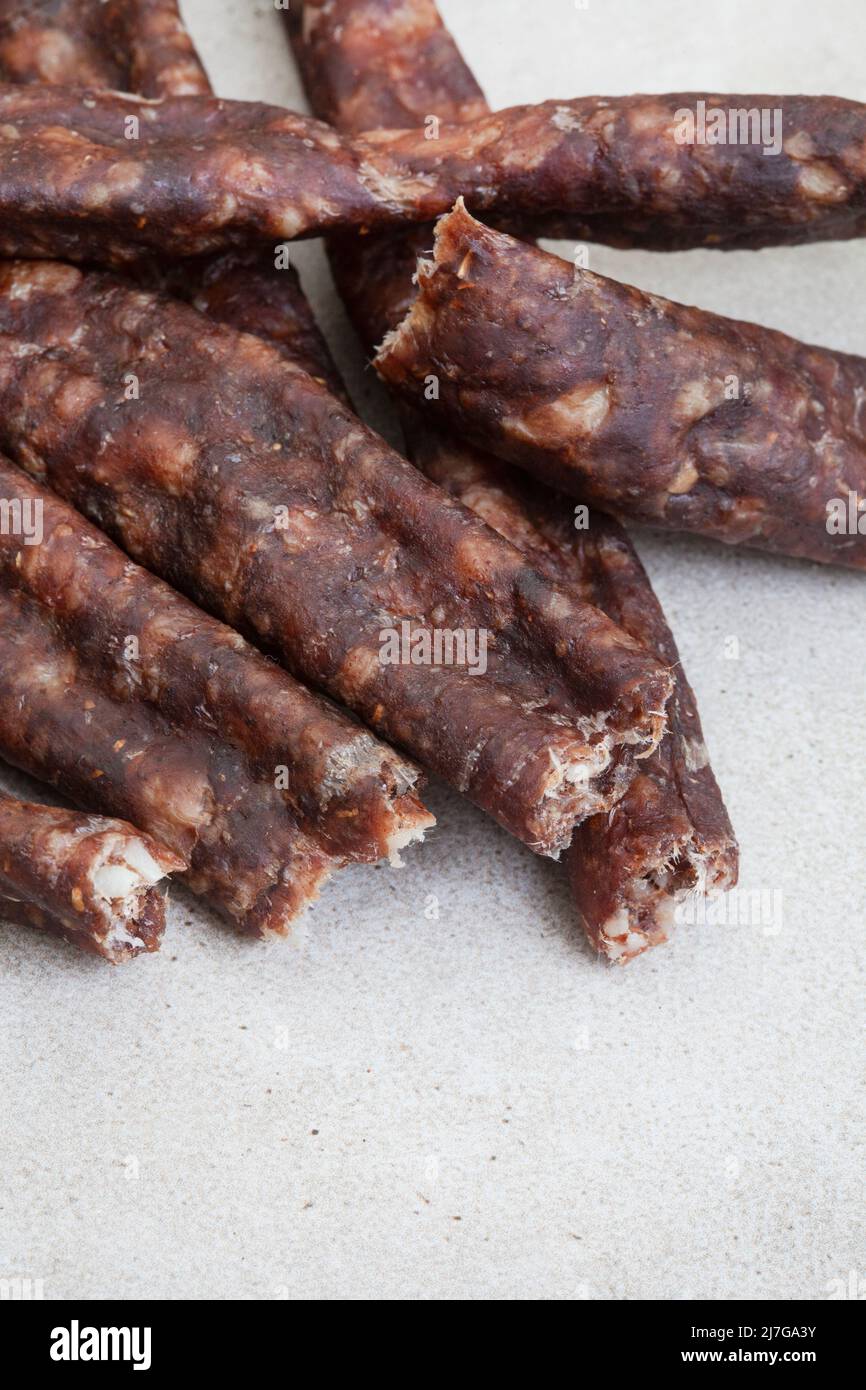 South African Dry Wors, a dried and cured sausage snack on grey, with copy space Stock Photo