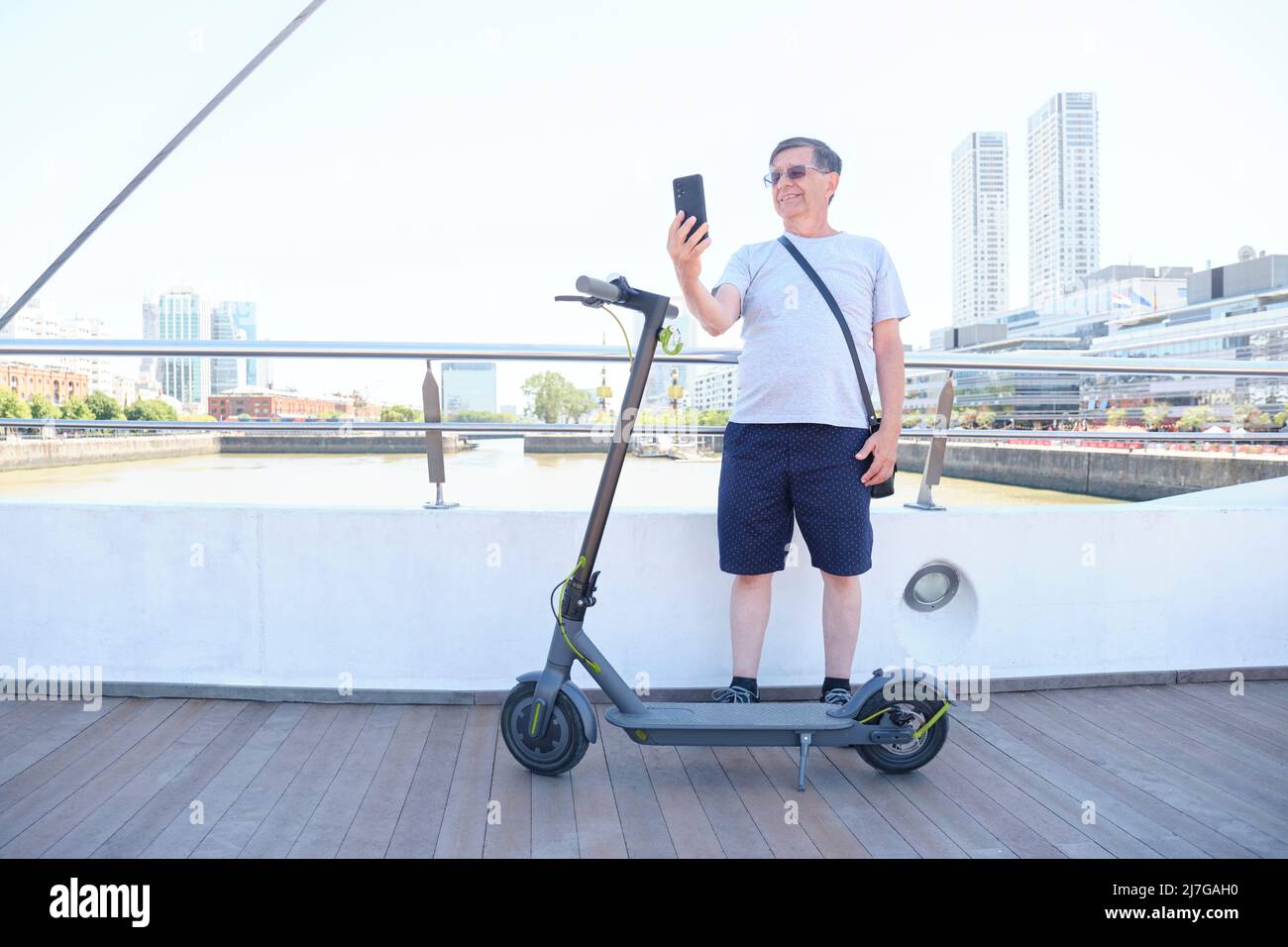 Hispanic man sightseeing in Puerto Madero, Buenos Argentina, with his electric and taking a selfie. Concept: senior person using Photo - Alamy