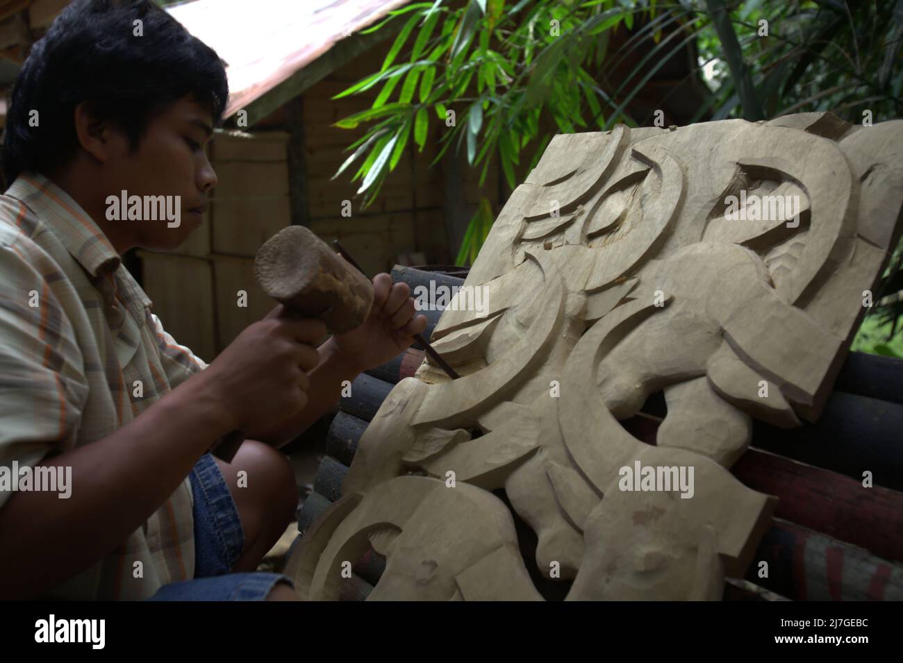 A man making wood carving in traditional village of Kete Kesu in North Toraja, South Sulawesi, Indonesia. Stock Photo