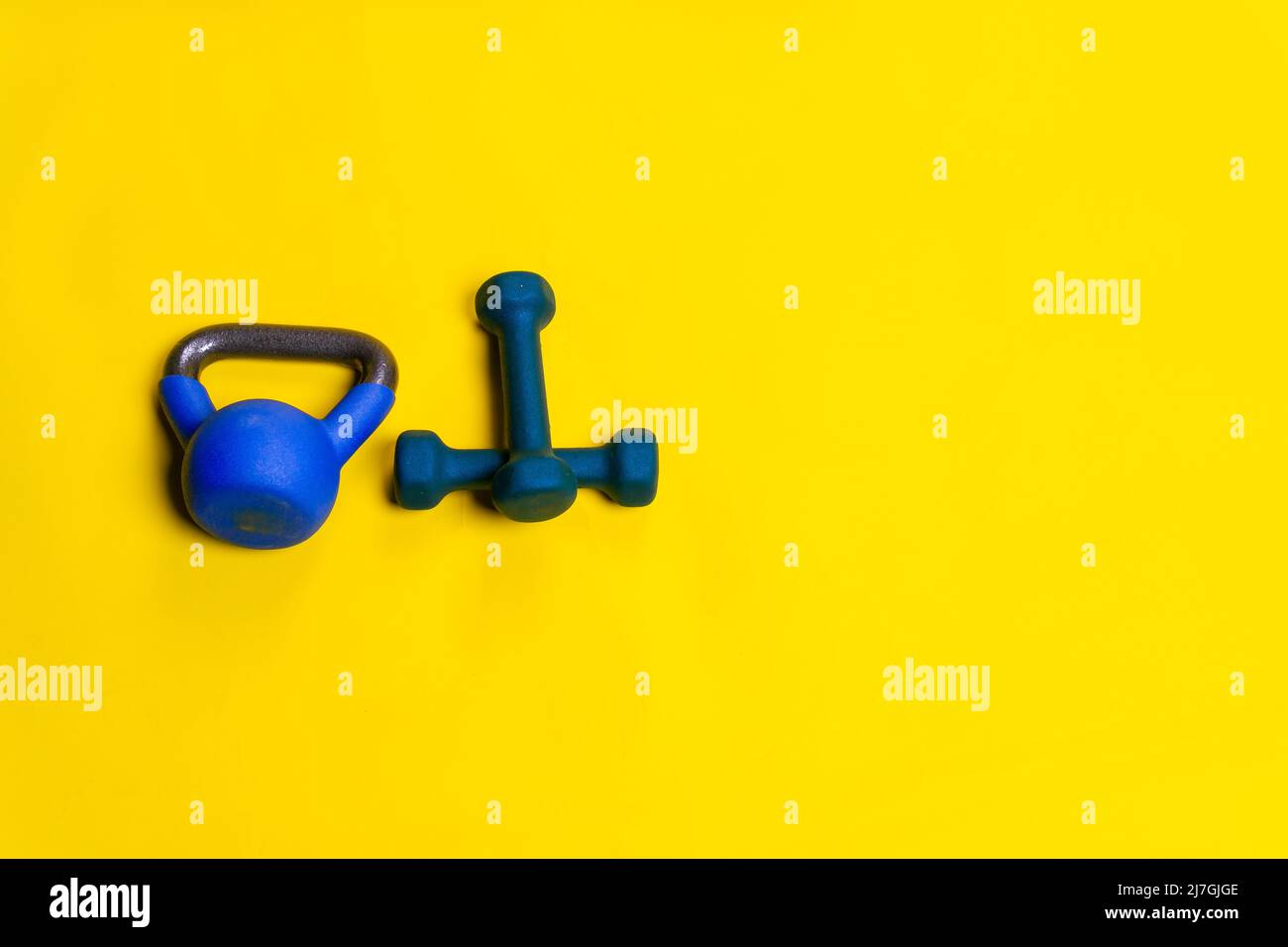 Kettlebell isolated blue space yellow ackground fitness cast exercise, for bodybuilding dumbbell for strength and workout kettle, simple vivid. Shape Stock Photo