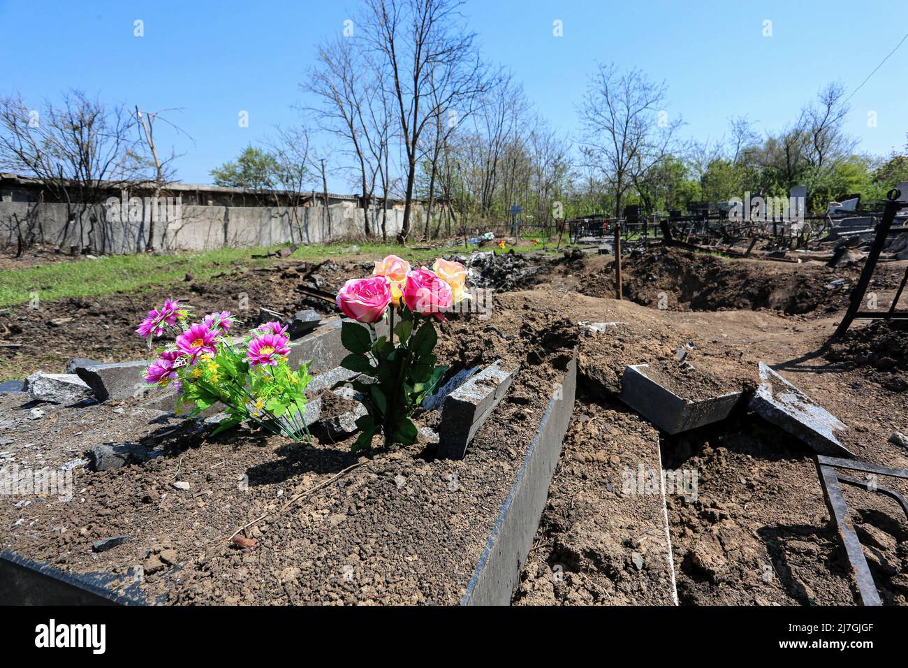Odessa, Ukraine. 6th May, 2022. Flowers against the background of destroyed graves during the Russia-Ukraine war. Russian shelling of Odessa, rockets hit Novo-Gorodskoe cemetery (or Tairovsky Cemetery). Destroyed more than 1000 square meters of the cemetery. (Credit Image: © Viacheslav Onyshchenko/SOPA Images via ZUMA Press Wire) Stock Photo