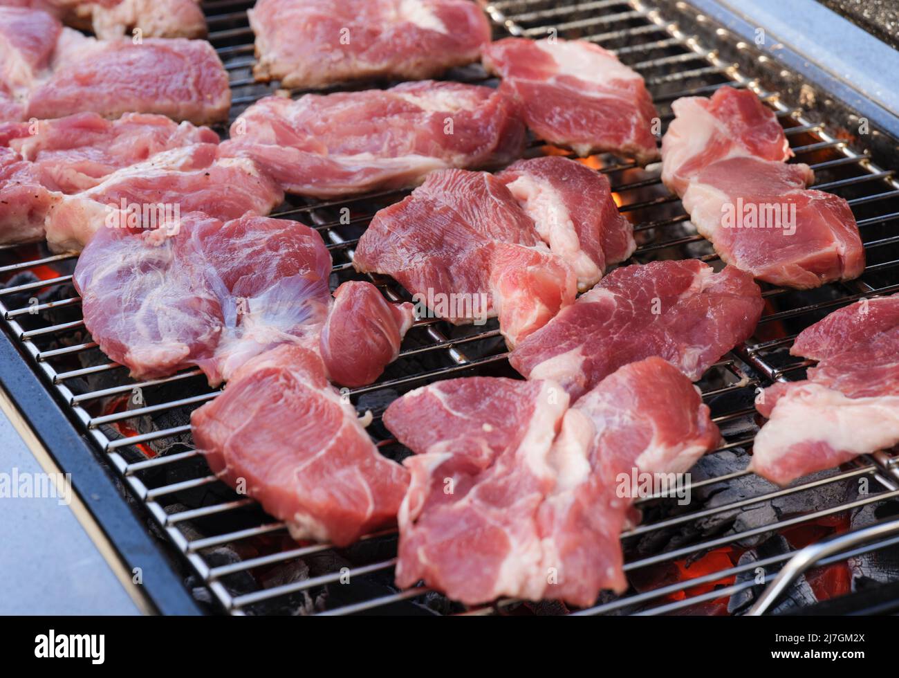 Organic pork meat cooking on a bbq grill. Close up. Stock Photo