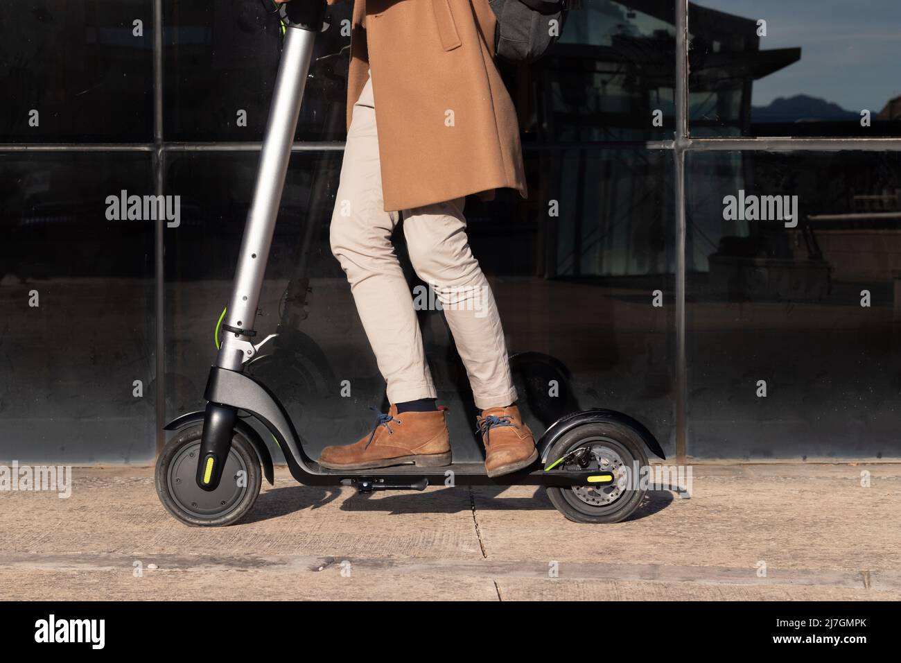 Crop view of man riding electric scooter as an alternative and eco