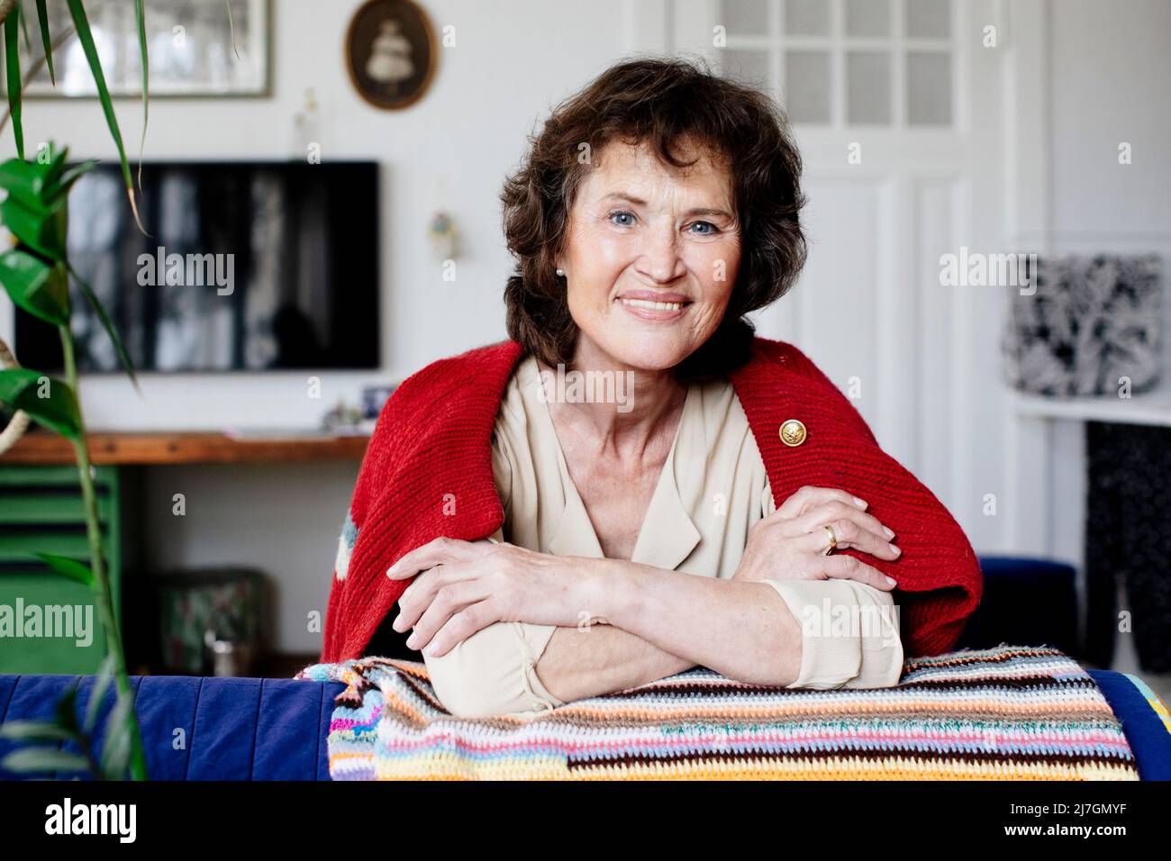 Portrait of a smiling senior woman sitting on couch Stock Photo - Alamy