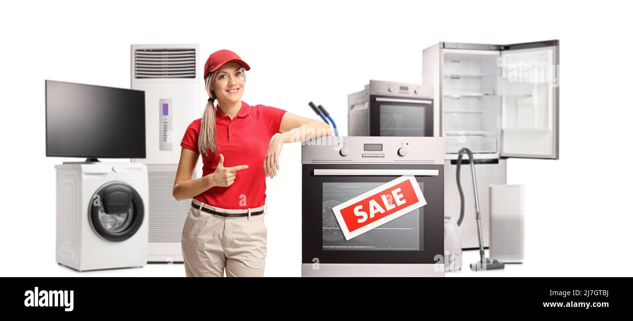 Saleswoman pointing to an electrical oven and other appliances in a store isolated on white background Stock Photo
