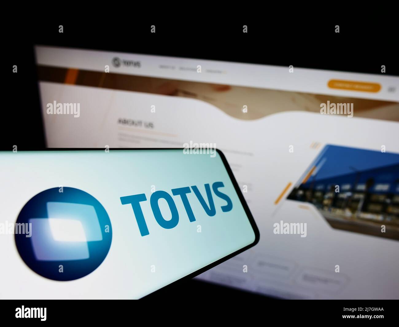 Mobile phone with logo of Brazilian software company TOTVS S.A. on screen in front of business website. Focus on center-right of phone display. Stock Photo