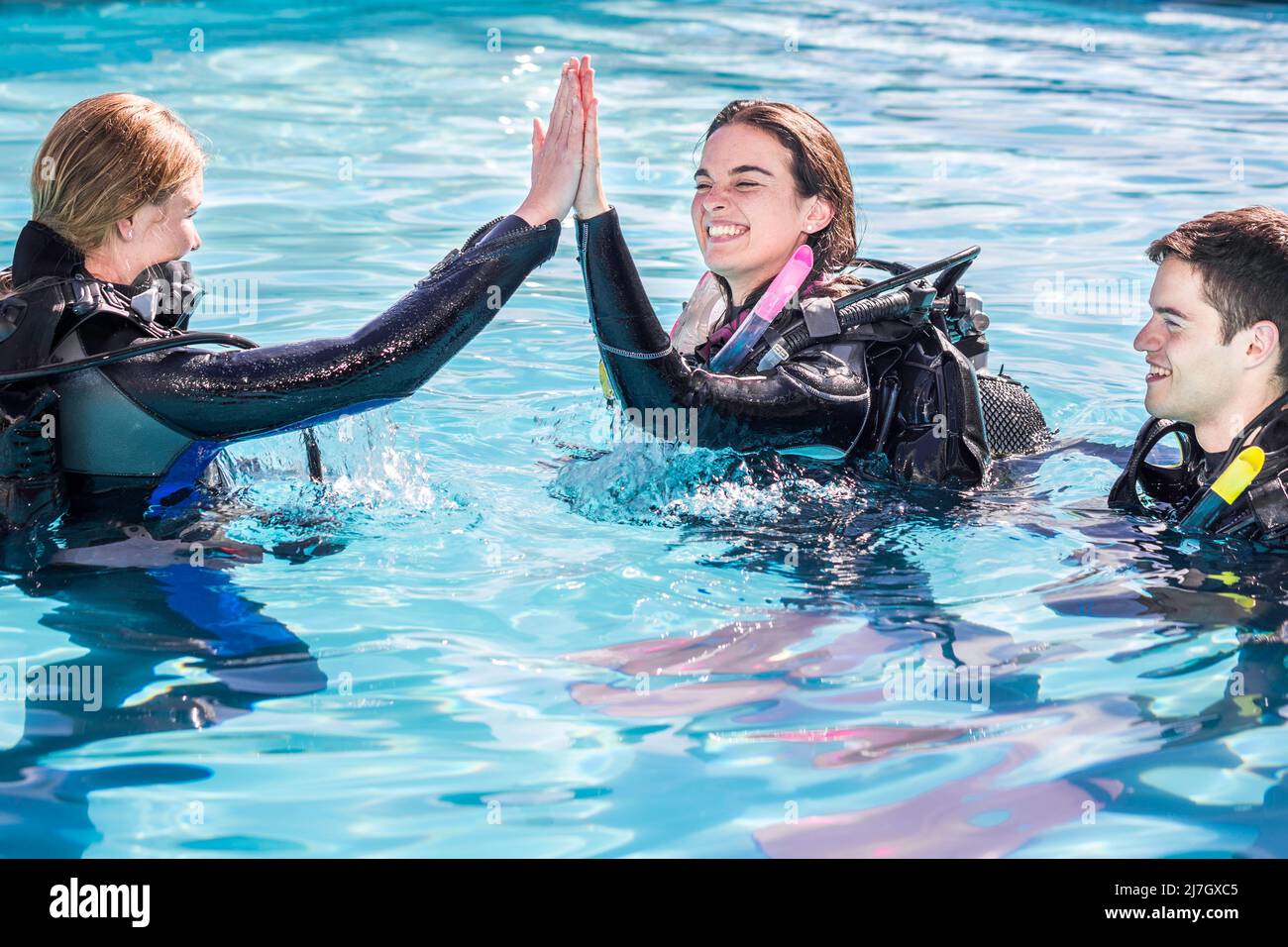 Scuba dive training in the pool with the instructor giving a high five to the happy student Stock Photo