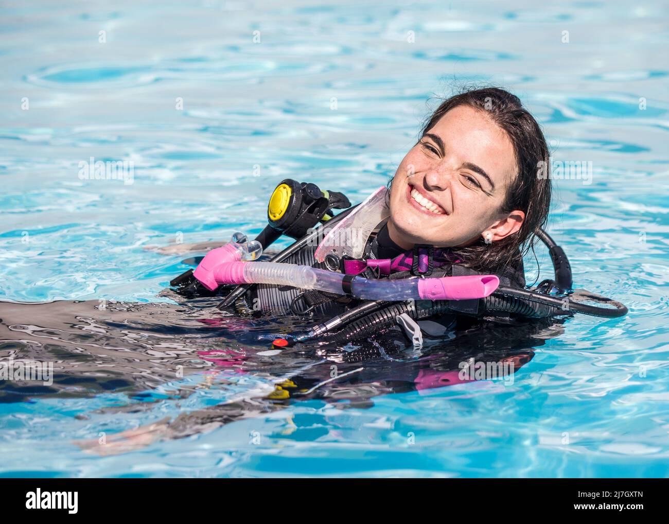 Young woman with scuba gear on in a pool smiling at the camera Stock Photo