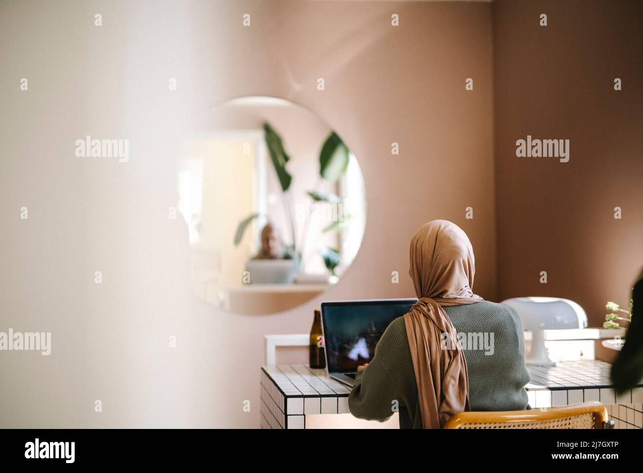 Young female freelancer using laptop while working from home Stock Photo