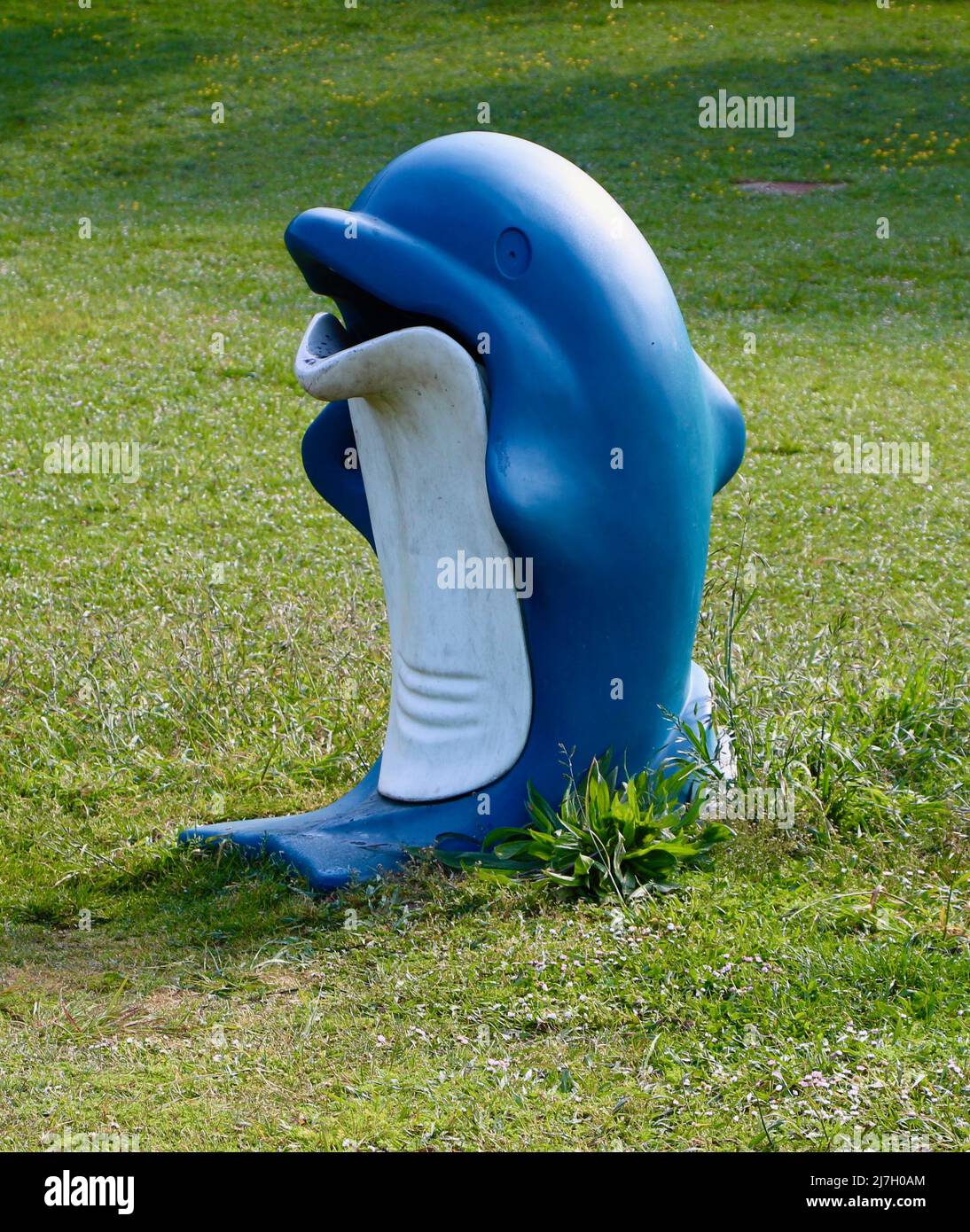 Blue and white plastic dolphin rubbish bin next to a children's playground  Stock Photo - Alamy