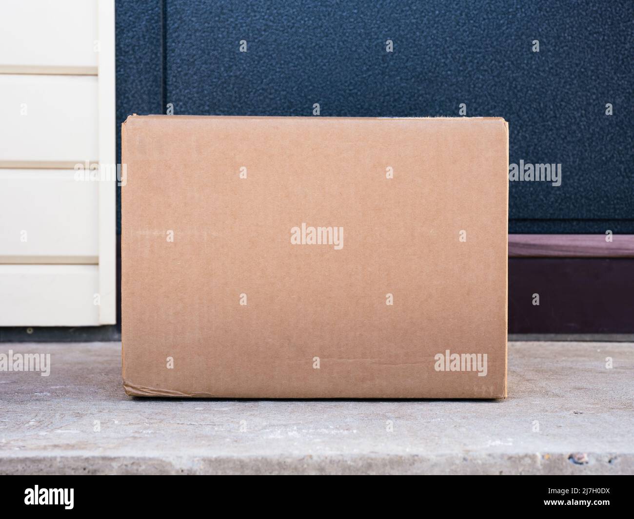 A cardboard box delivered to the house door. Closeup Stock Photo Alamy