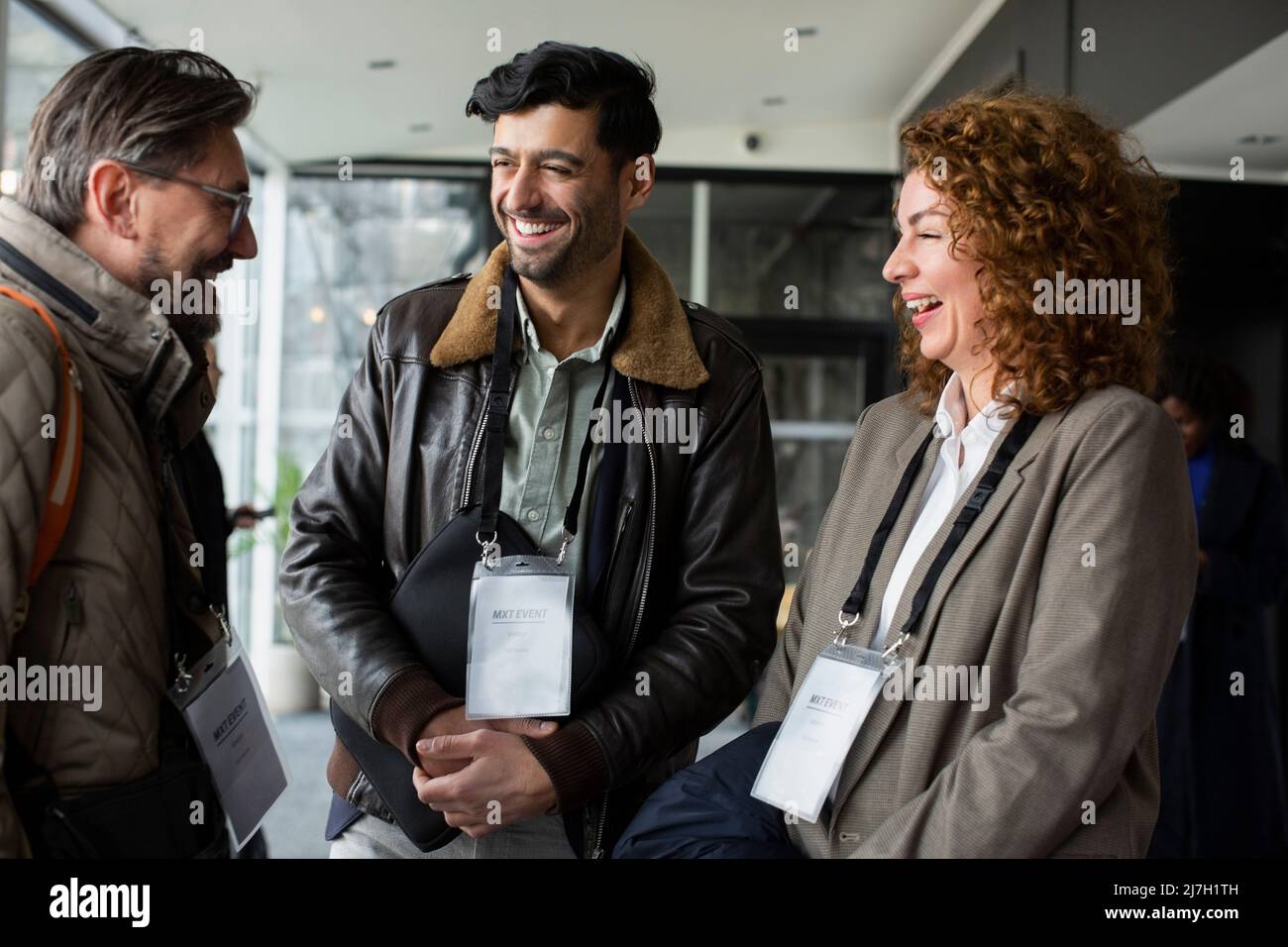 Visiting Delegates Happy delegates talking with businessman during seminar at conference ...