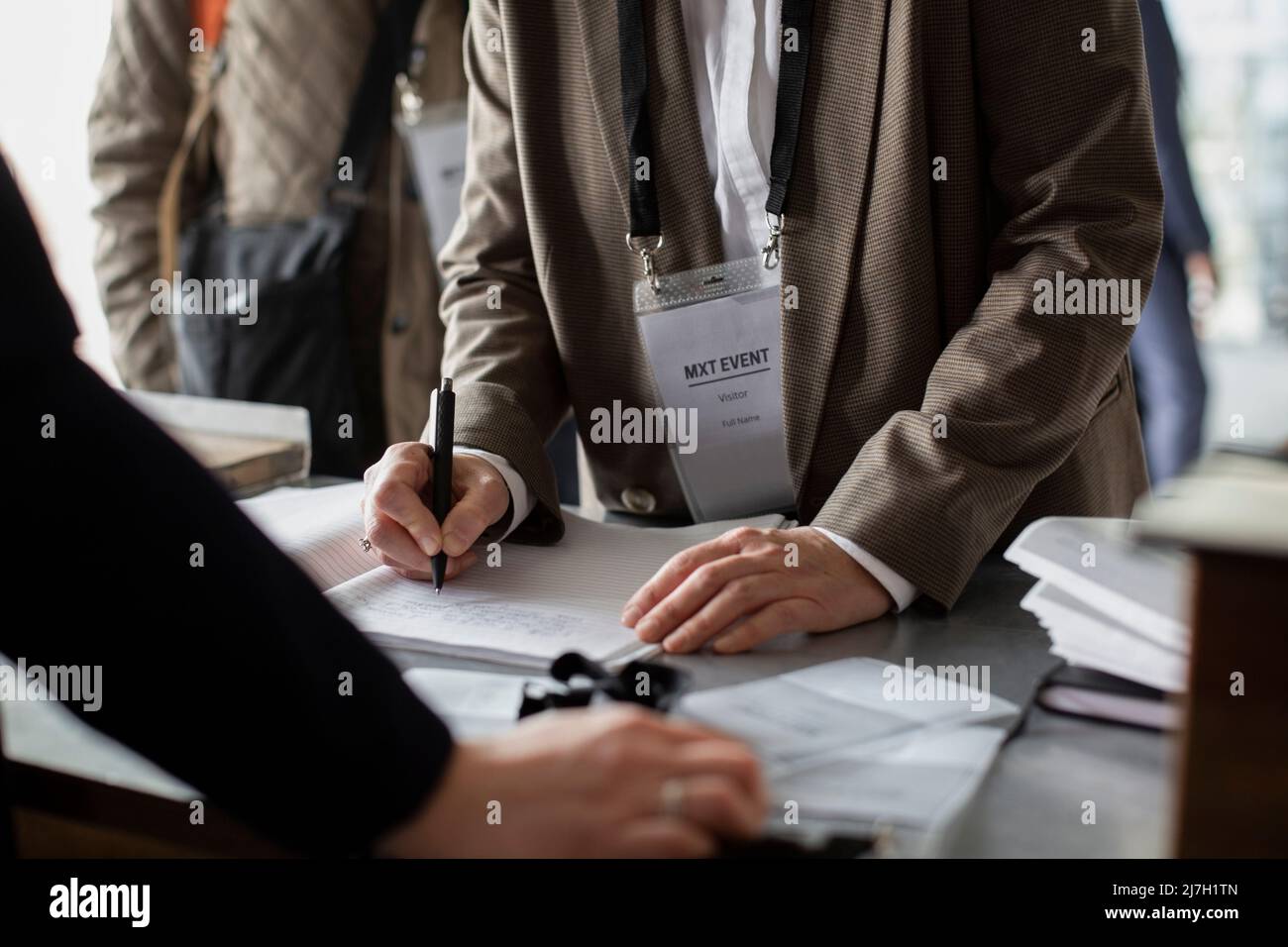 Midsection of businesswoman registering at counter during seminar Stock Photo