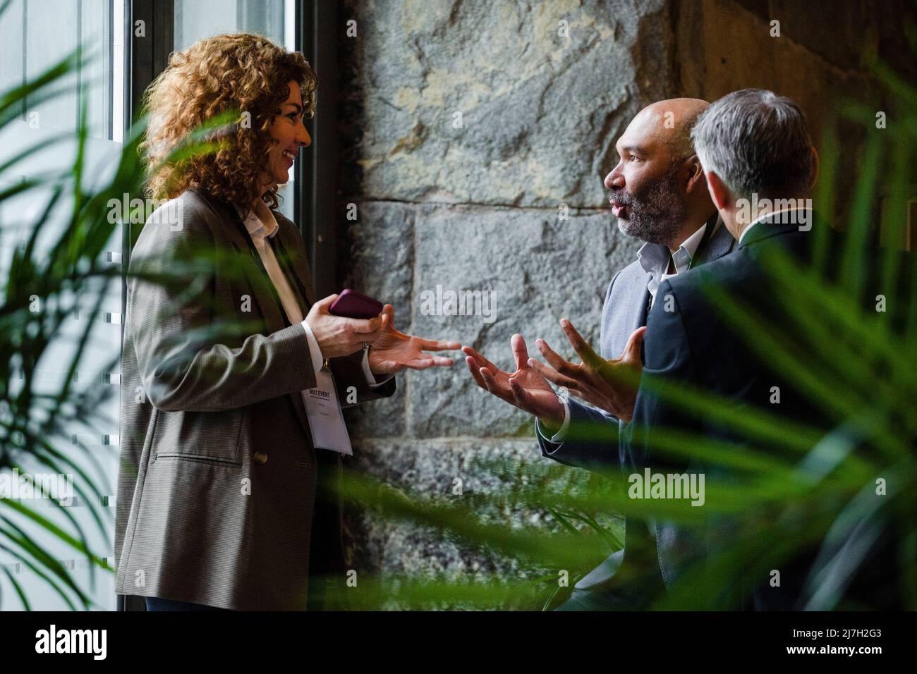 Business professionals gesturing while talking to each other in conference center Stock Photo