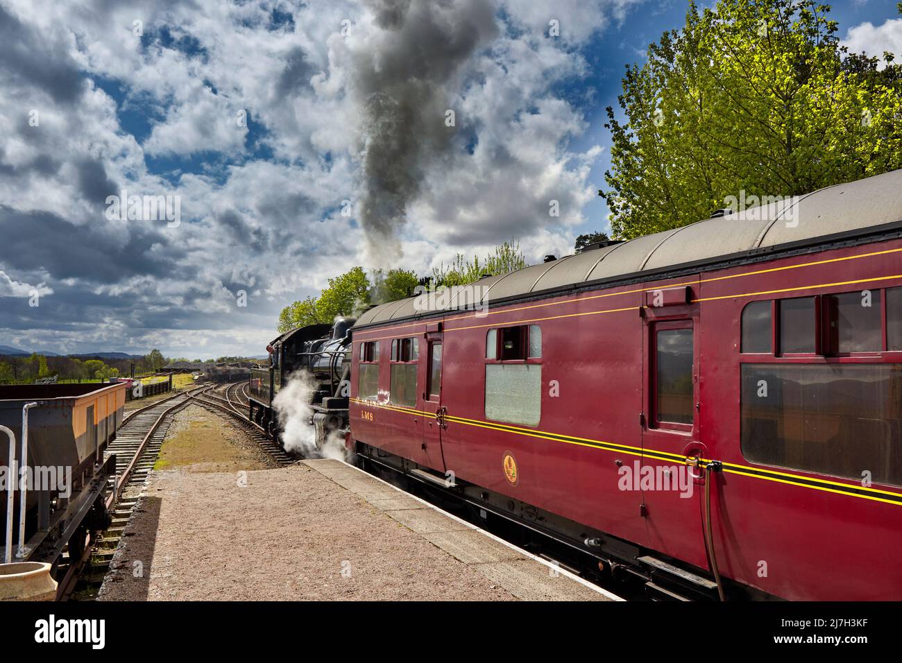 STRATHSPEY RAILWAY BROOMHILL STATION SCOTLAND THE STEAM TRAIN LEAVING THE PLATFORM A PLUME OF SMOKE FROM THE FUNNEL OR SMOKESTACK Stock Photo