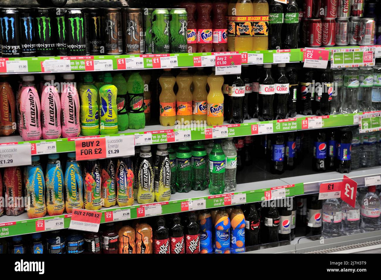 Bottles and cans of soft drinks on supermarket shelves, UK Stock Photo