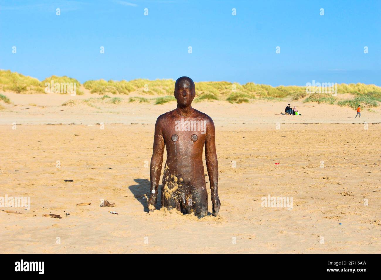 'Another Place' man cast-iron sculpture by Antony Gormley in the sand on Crosby Beach, England Stock Photo