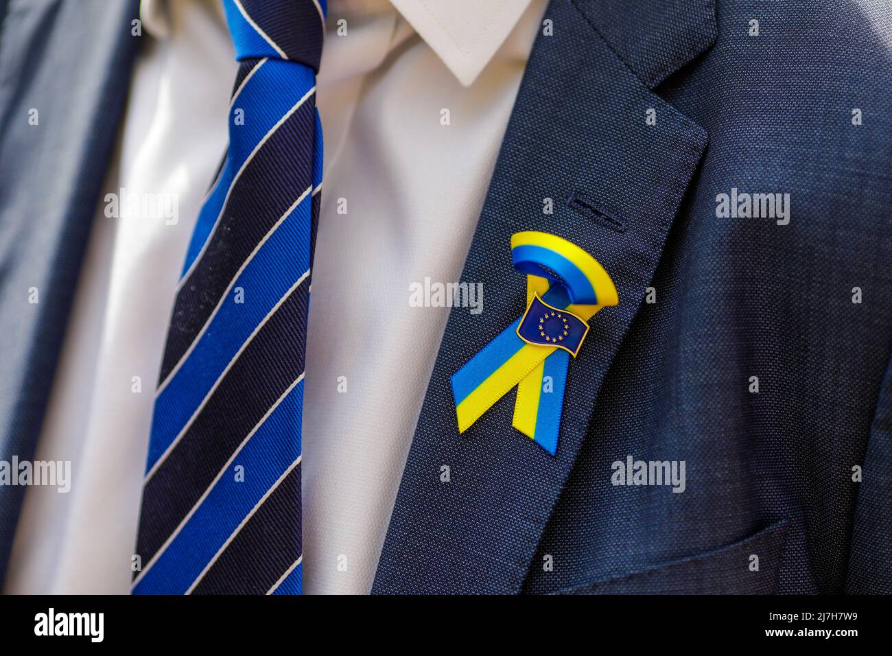 Bucharest, Romania - May 9, 2022: Shallow depth of field (selective focus) details with the Ukrainian flag and the European Union logo on the suit of Stock Photo
