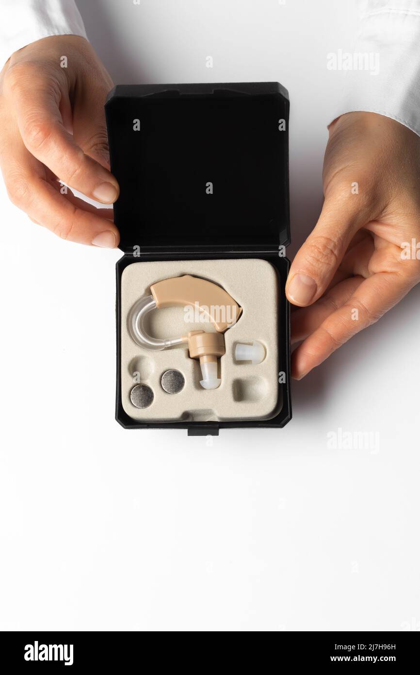 Hearing aid in a box in the hands of a doctor. Stock Photo