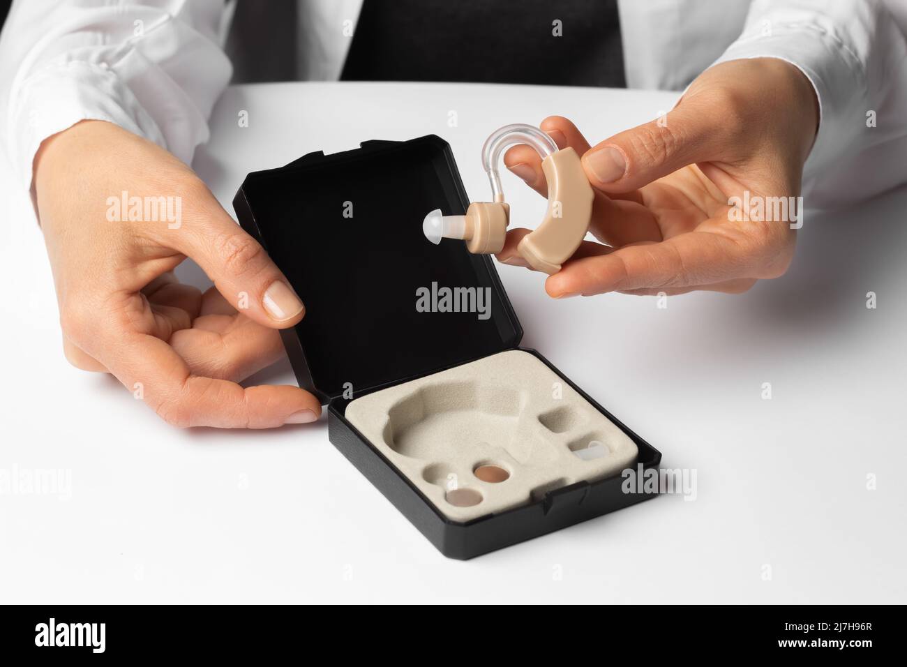 Hearing aid in a box in the hands of a doctor. Stock Photo