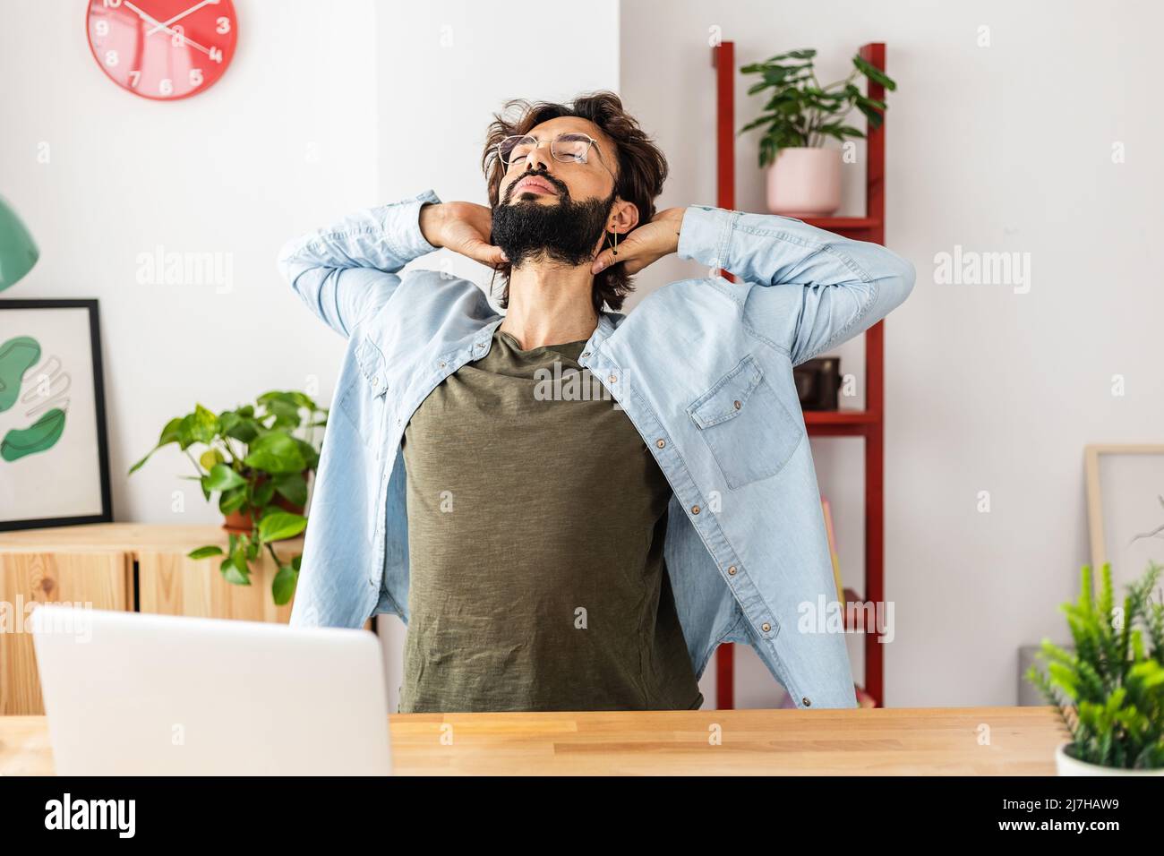 Hipster young man doing a stretching exercise while taking a break from work Stock Photo