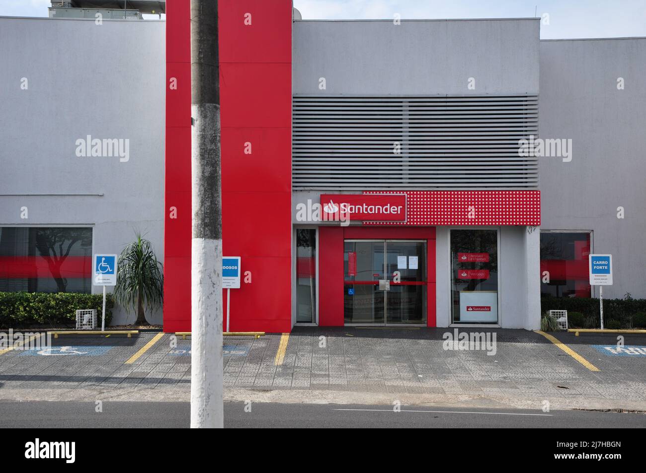 Facade of Santander Banking Agency, City Marilia, Sao Paulo, Brazil. August 30, 2021. Facade of the Banco Santander branch, with priority parking plat Stock Photo