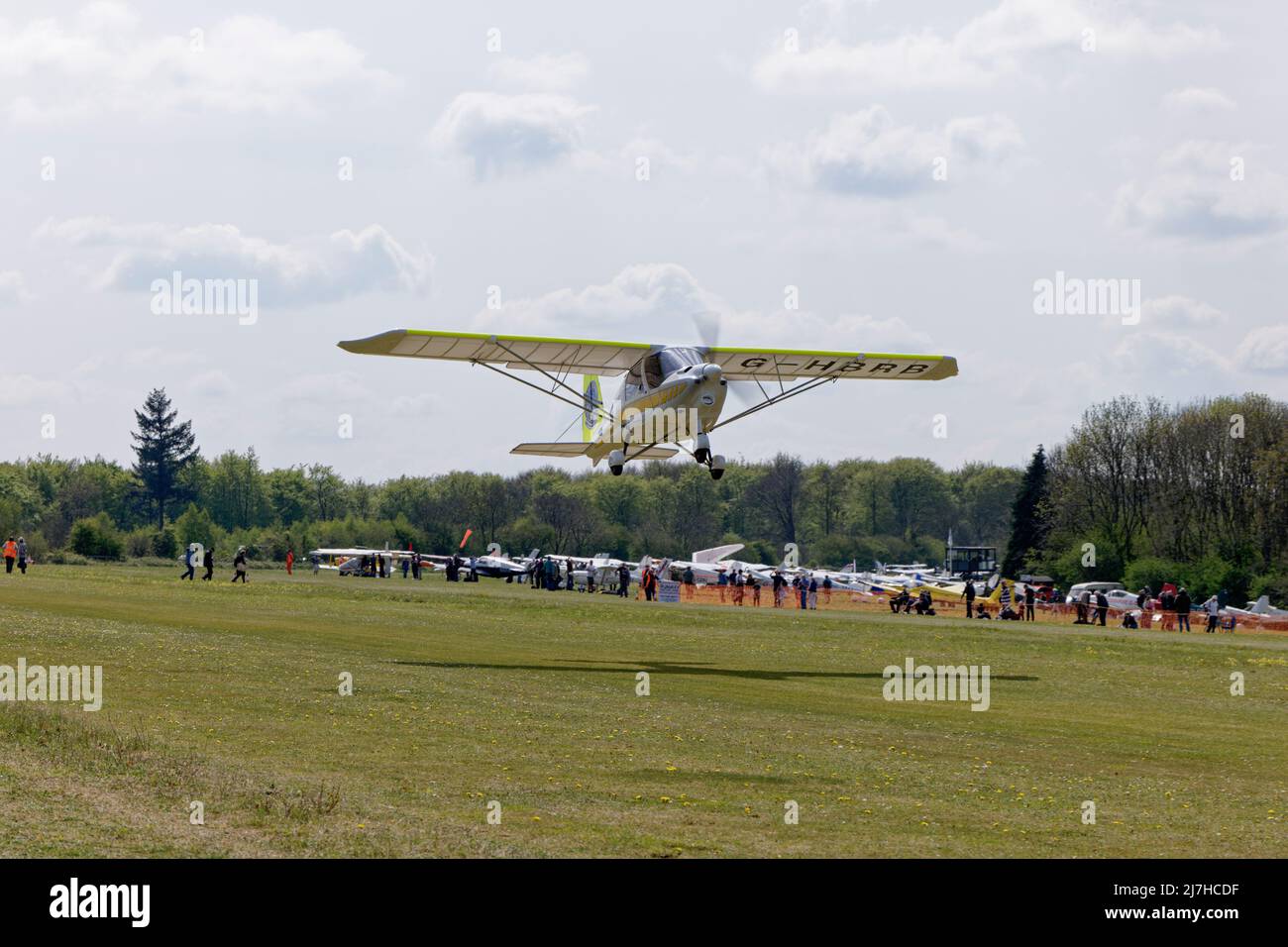 Ikarus C42 Microlight airplane G-HBRB of the Air Adventures Flying Club takes off from the grass runway at Popham Airfield near Basingstoke Stock Photo