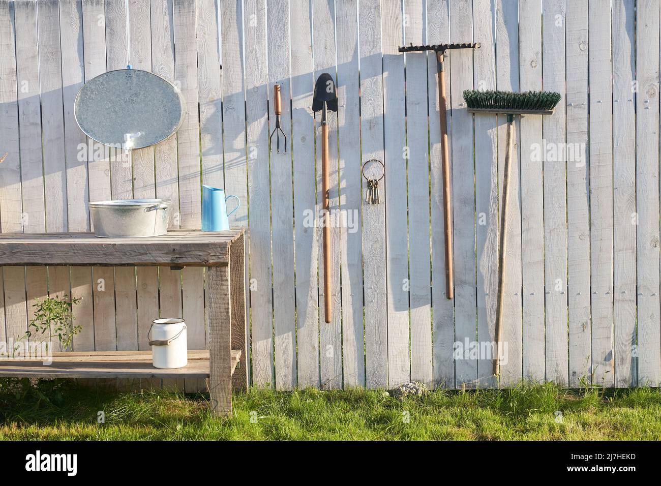 Garden tools on the background of a white fence. The concept of agricultural, garden utensils. Outdoor Gardening tools and Accessories. High quality photo Stock Photo