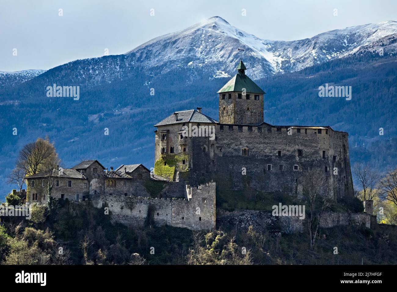 The imposing fortified structure of Ivano castle stands out among the Valsugana mountains. Castel Ivano, Trento province, Trentino Alto-Adige, Italy. Stock Photo
