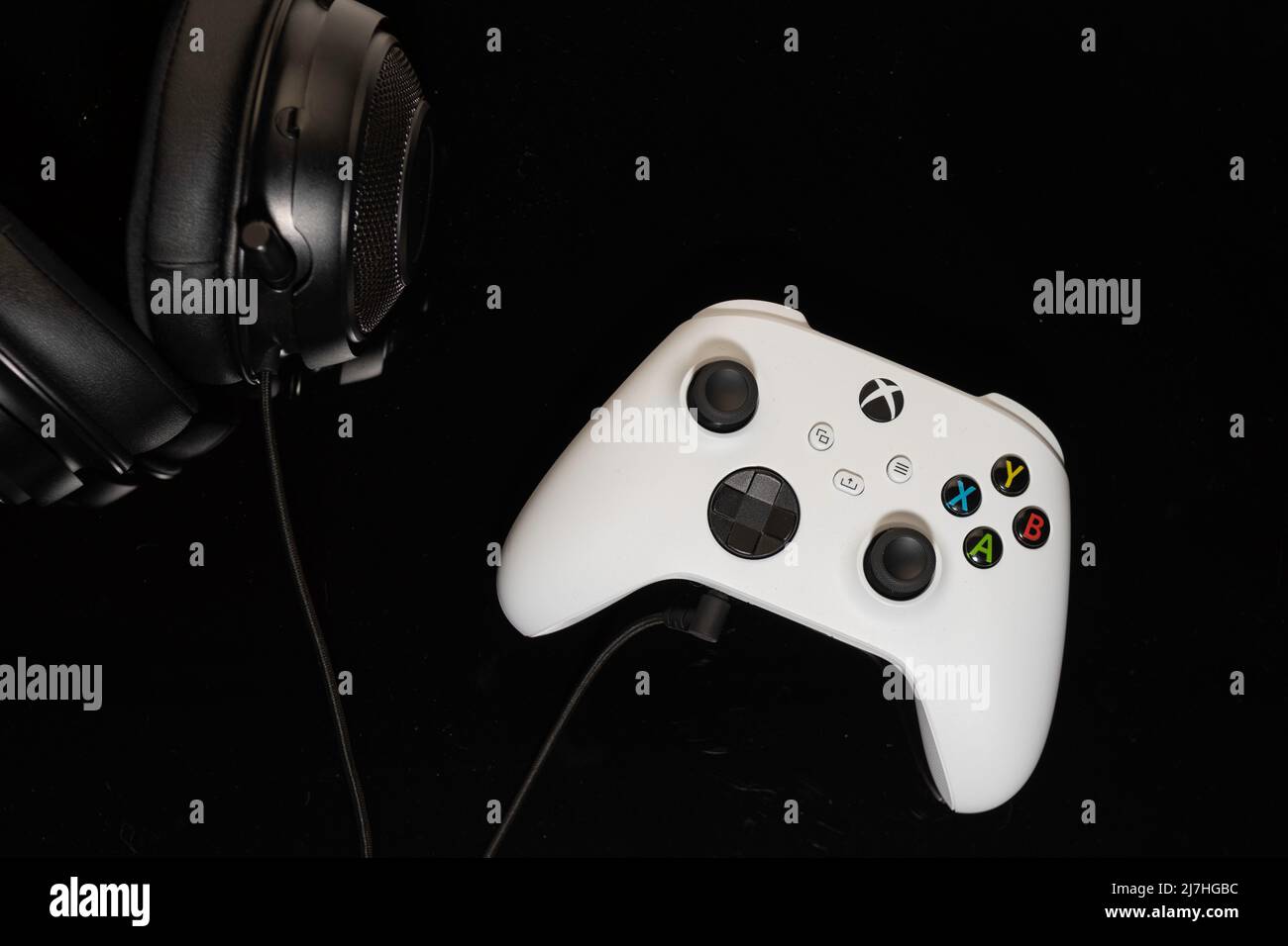 Microsoft Xbox gaming controller with headphones on black background Stock Photo